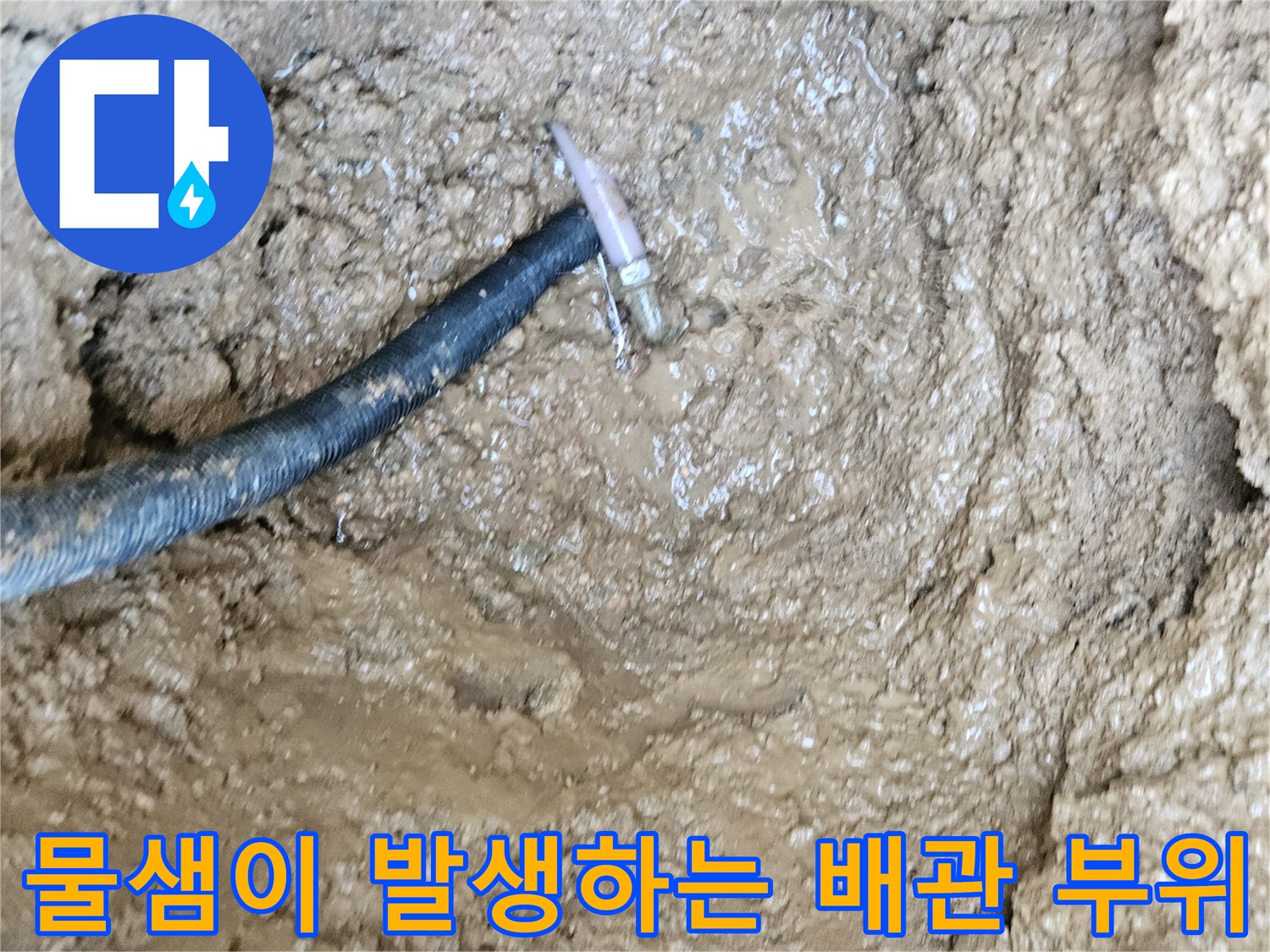 축축한 토양 속에 노출된 파손된 수도 배관 연결부
