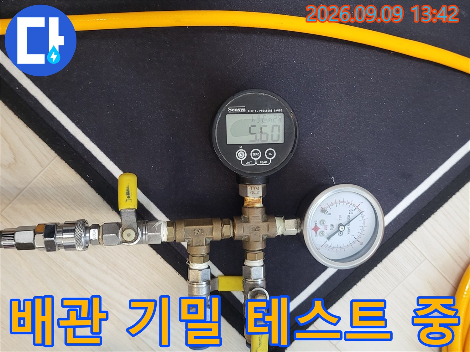 금속 배관 부속과 압력 측정 게이지가 연결된 정밀 진단 장비 이미지입니다.