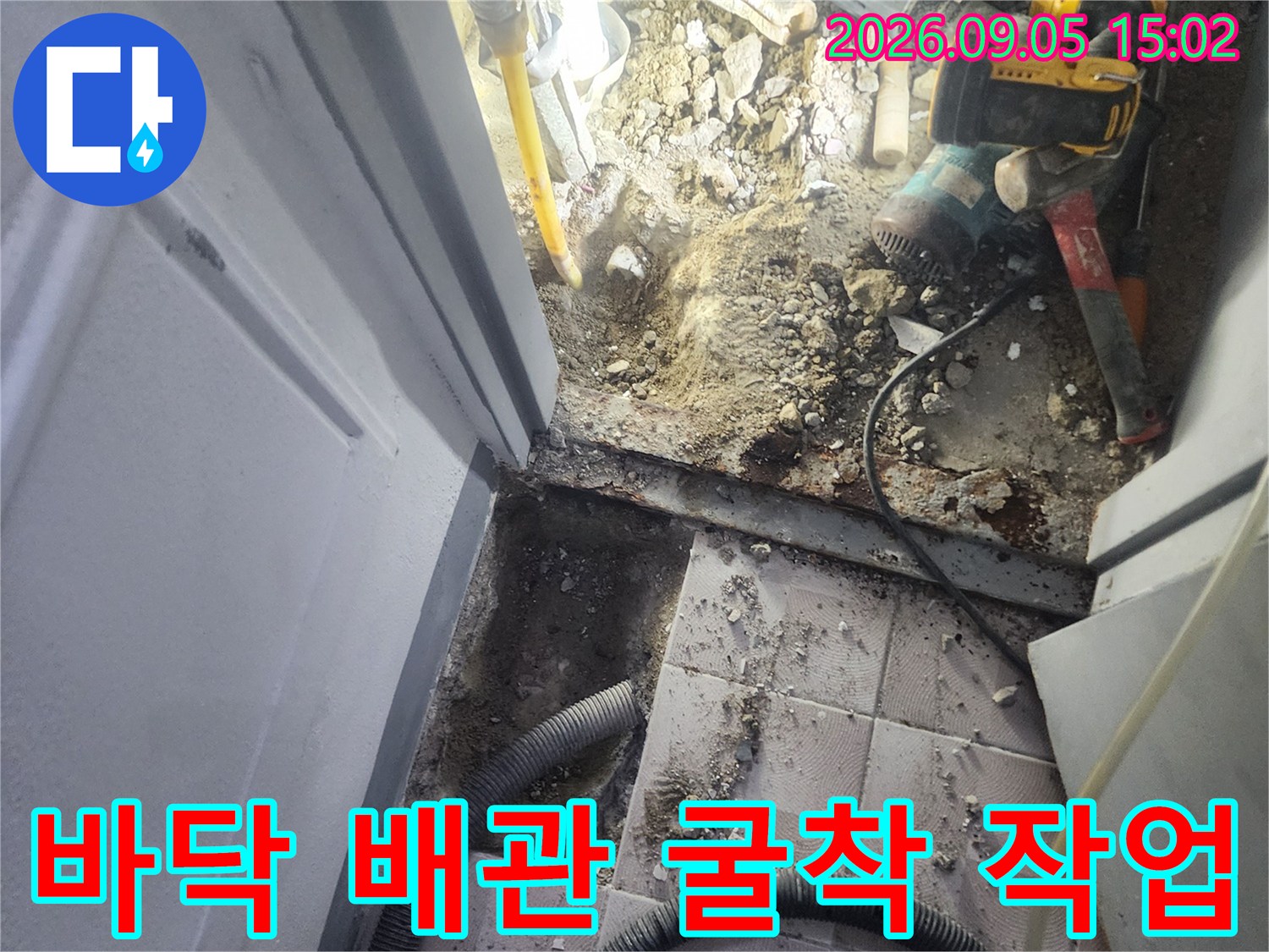 아파트 바닥을 굴착하여-노출된 배관 및 작업 도구들