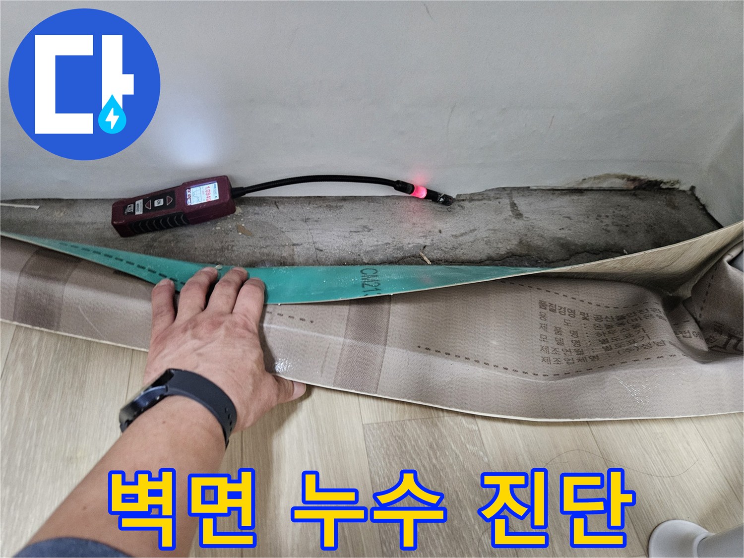 누수-탐지기를-벽체-하단부-배관-라인에-대고-조사하는-모습