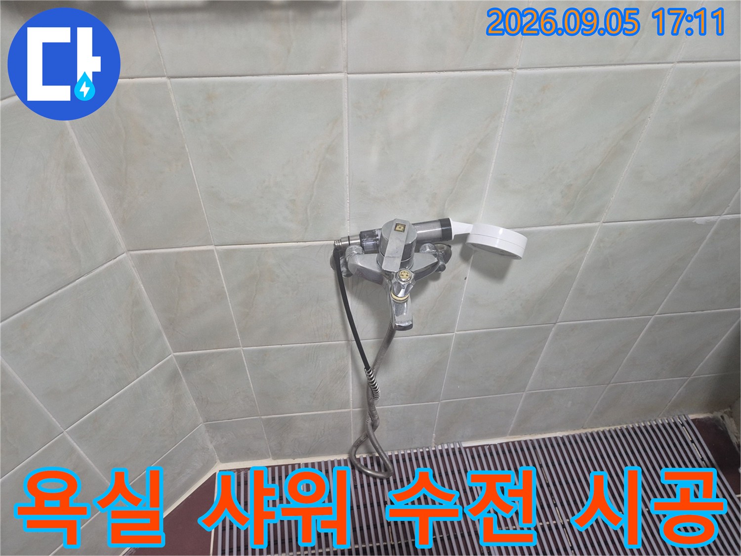 깨끗한 타일 벽면에 설치된 신규 샤워기 수전과 호스