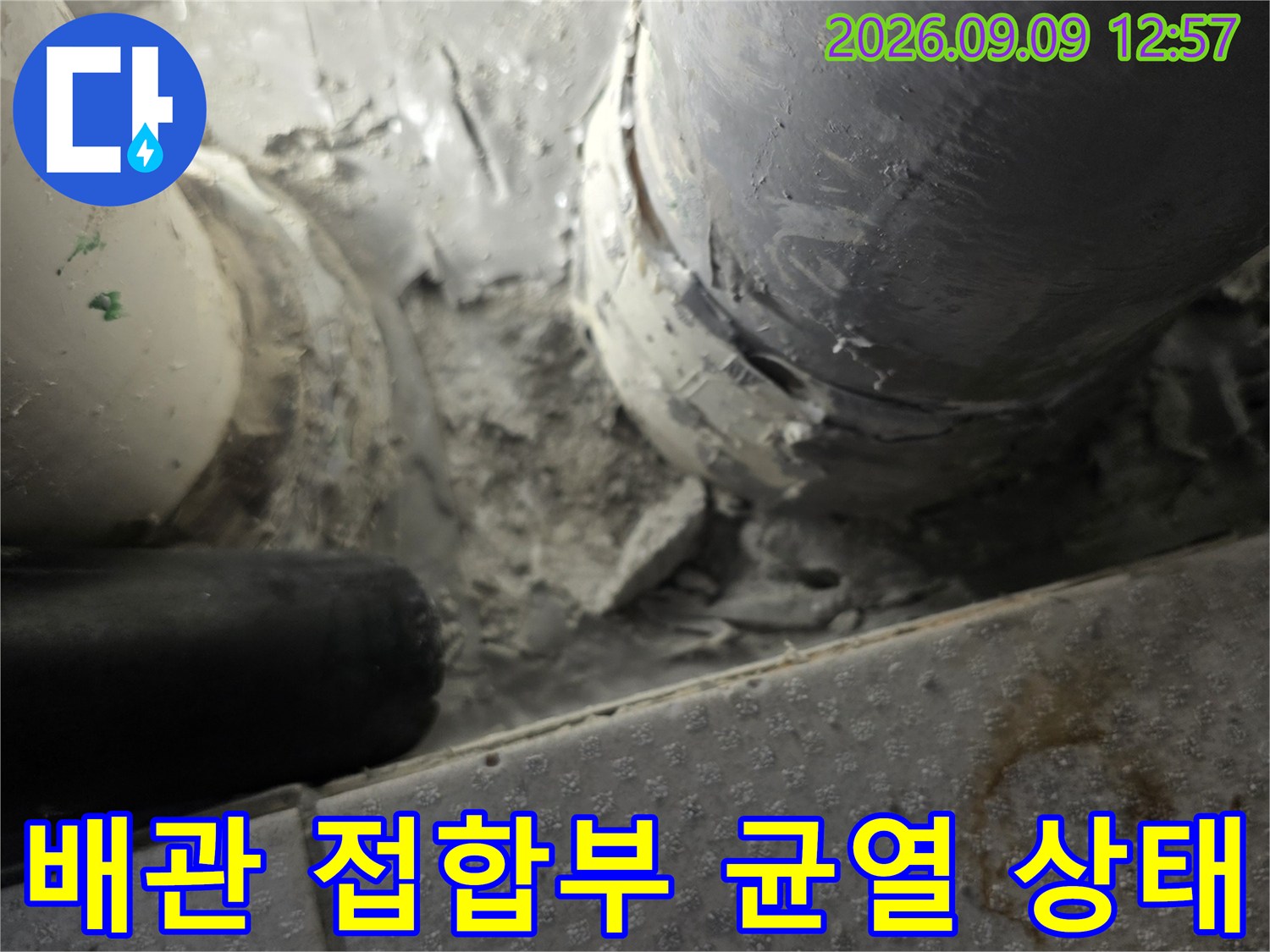 균열이 발생한 배관 접합부와 주변 시멘트 마감면을 근접 촬영하였습니다.