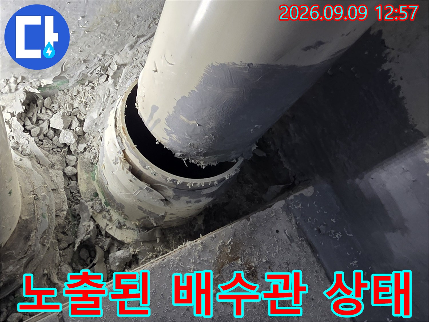 정리되지 않은-배수관 주변의 시멘트 파편과 노출된 관 부위