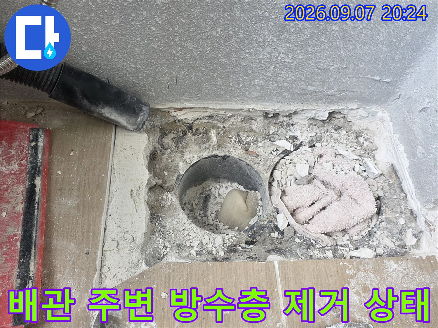 배수구 배관 주변의 낡은 마감재와 타일을 제거한 현장 모습입니다.