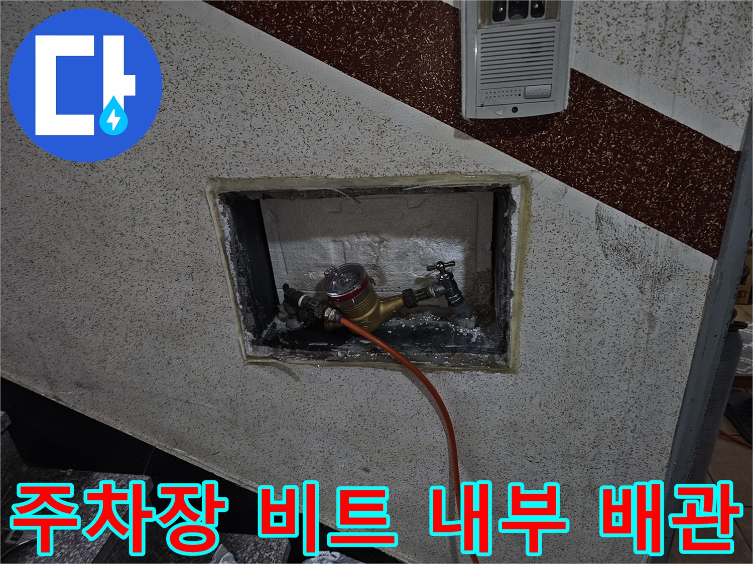 벽면 타공 부위 내부에 노출된 수도 계량기와 배관 연결 상태