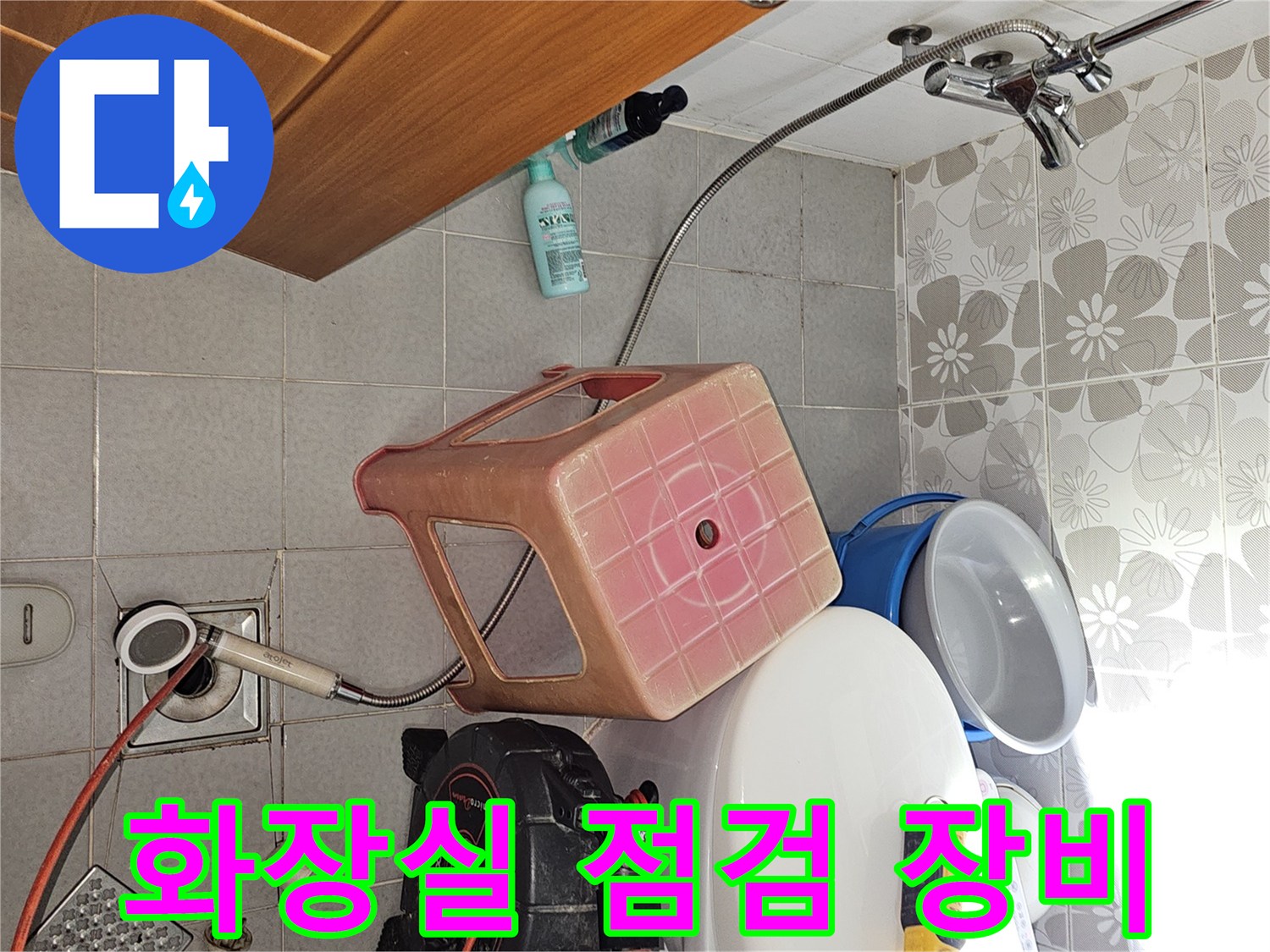 욕실 바닥에 놓인 누수 탐지용 압력 측정기와 전동 드릴