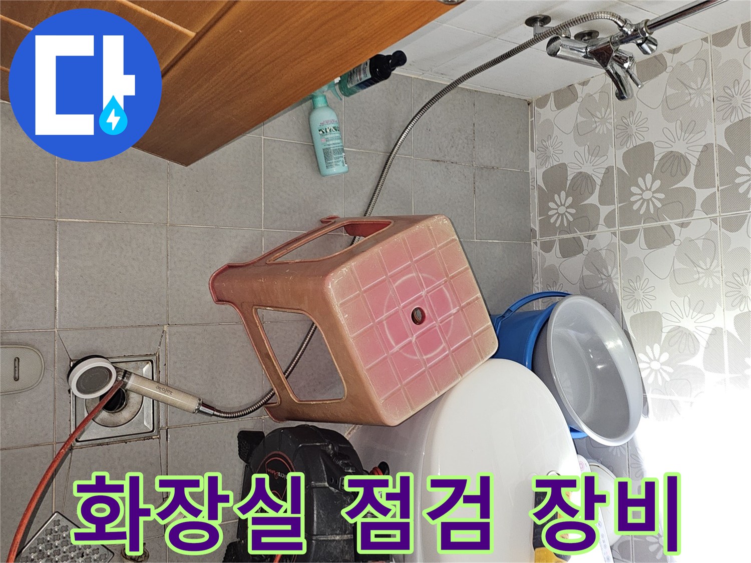 화장실 바닥에 배치된 배관 압력 테스트용 측정기와 케이블 릴