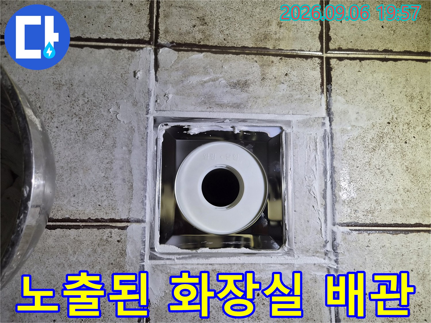 타일 작업면 아래-노출된 오수관과 주변 마감 상태입니다