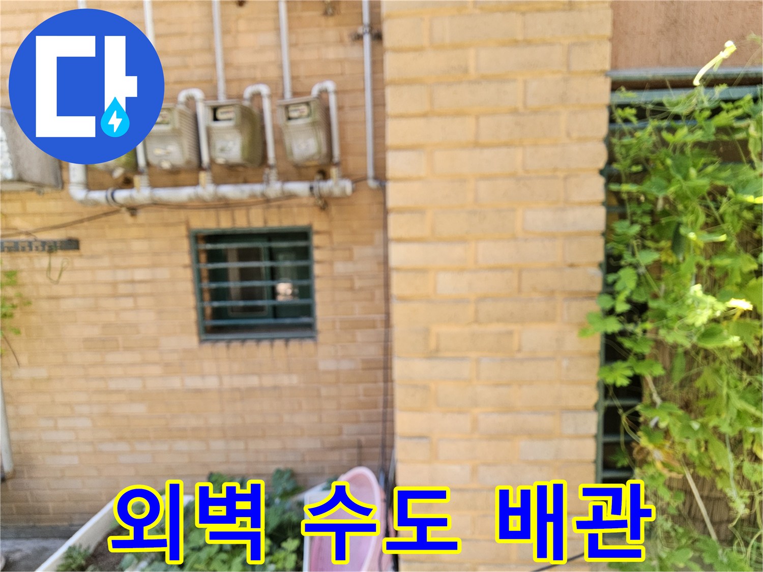 건물 벽면에 설치된 수도 계량기와 연결 배관입니다.