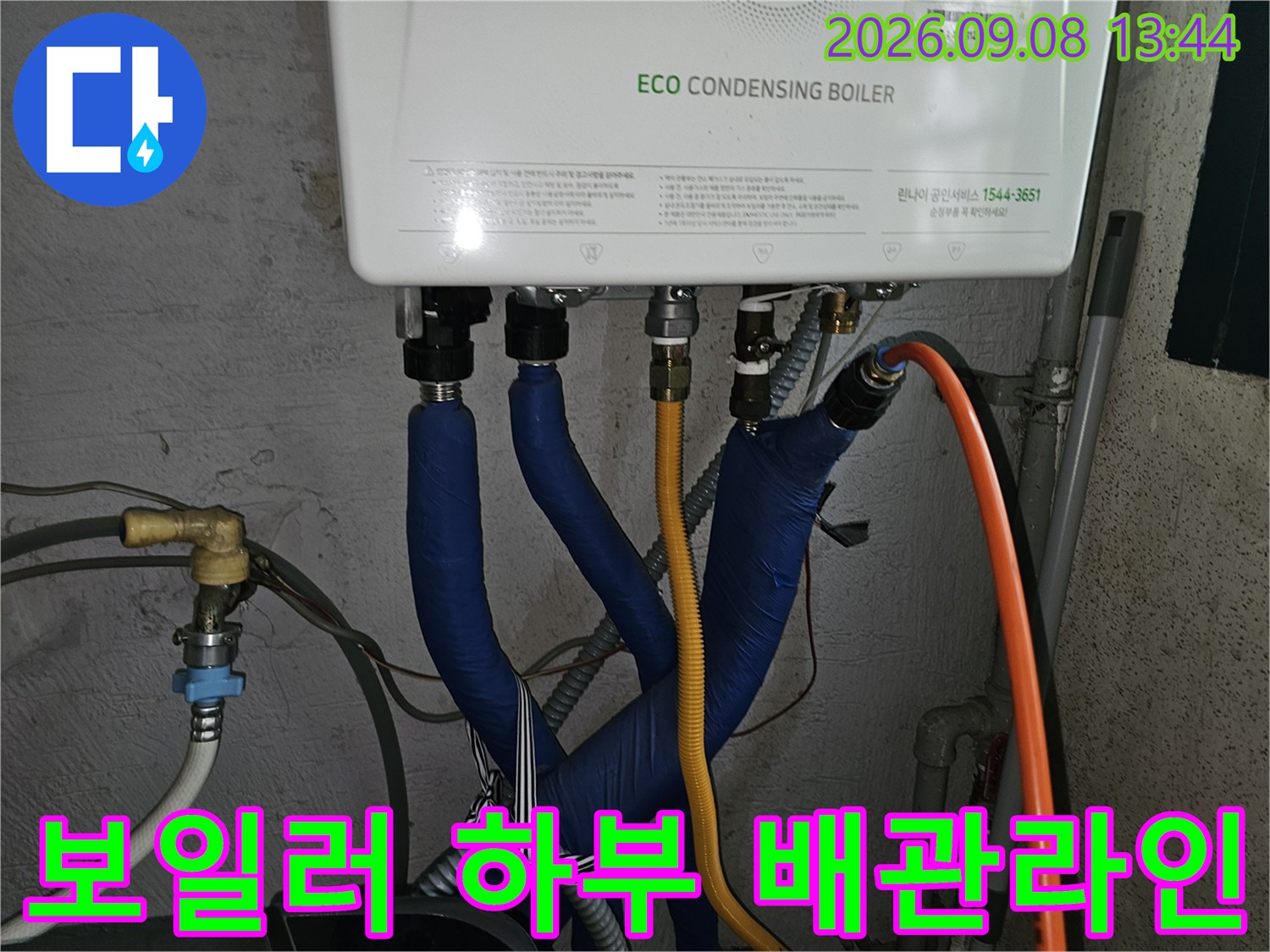 보일러 하단의 파란색 단열재와 노란색 호스가 연결된 설비 현장 사진