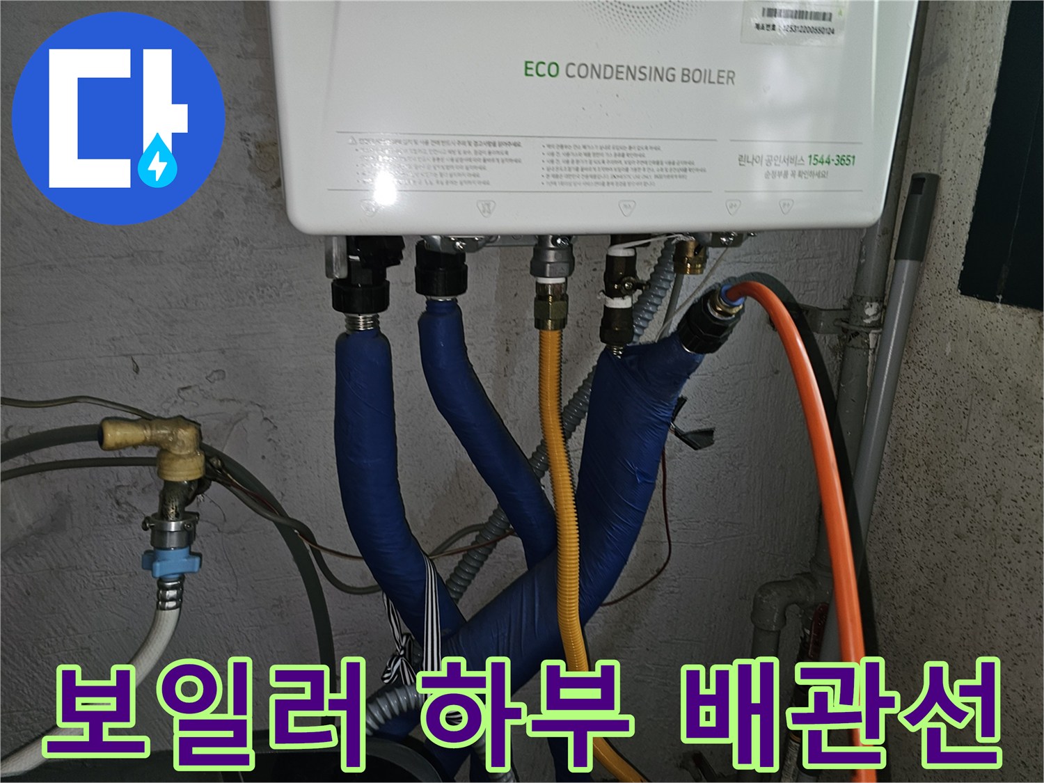 파란색 보온재와 노란색 호스가 연결된 보일러 하단 모습