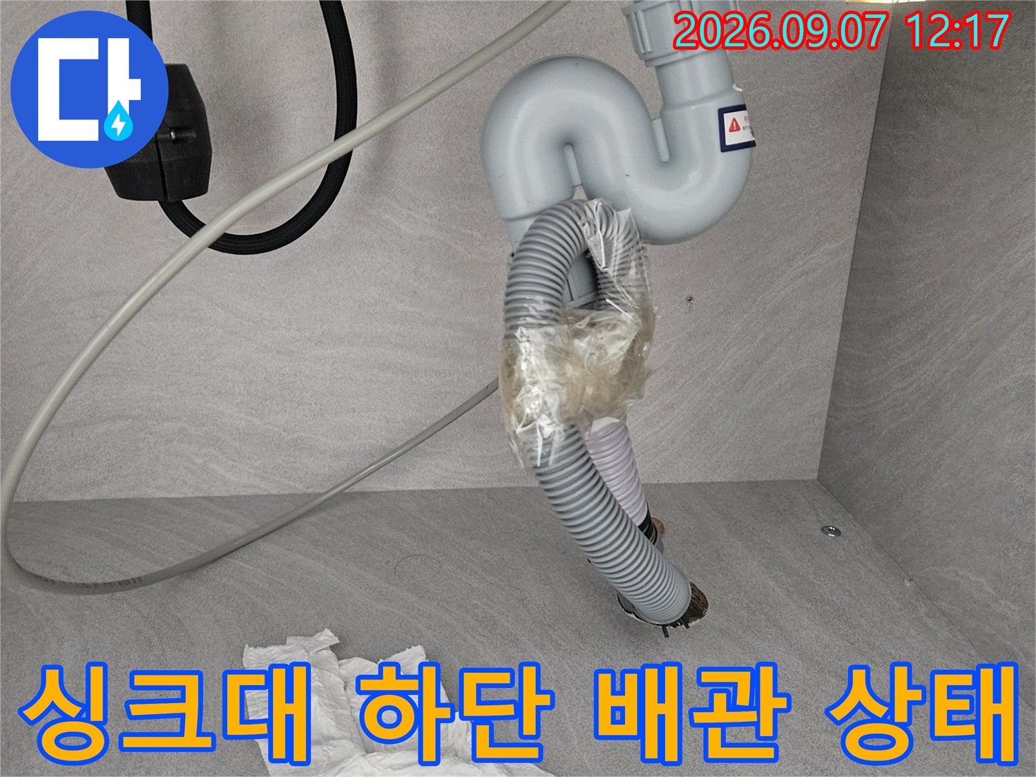 싱크대 아래쪽 훼손된 주름관과 연결 호스 부위 상세 사진