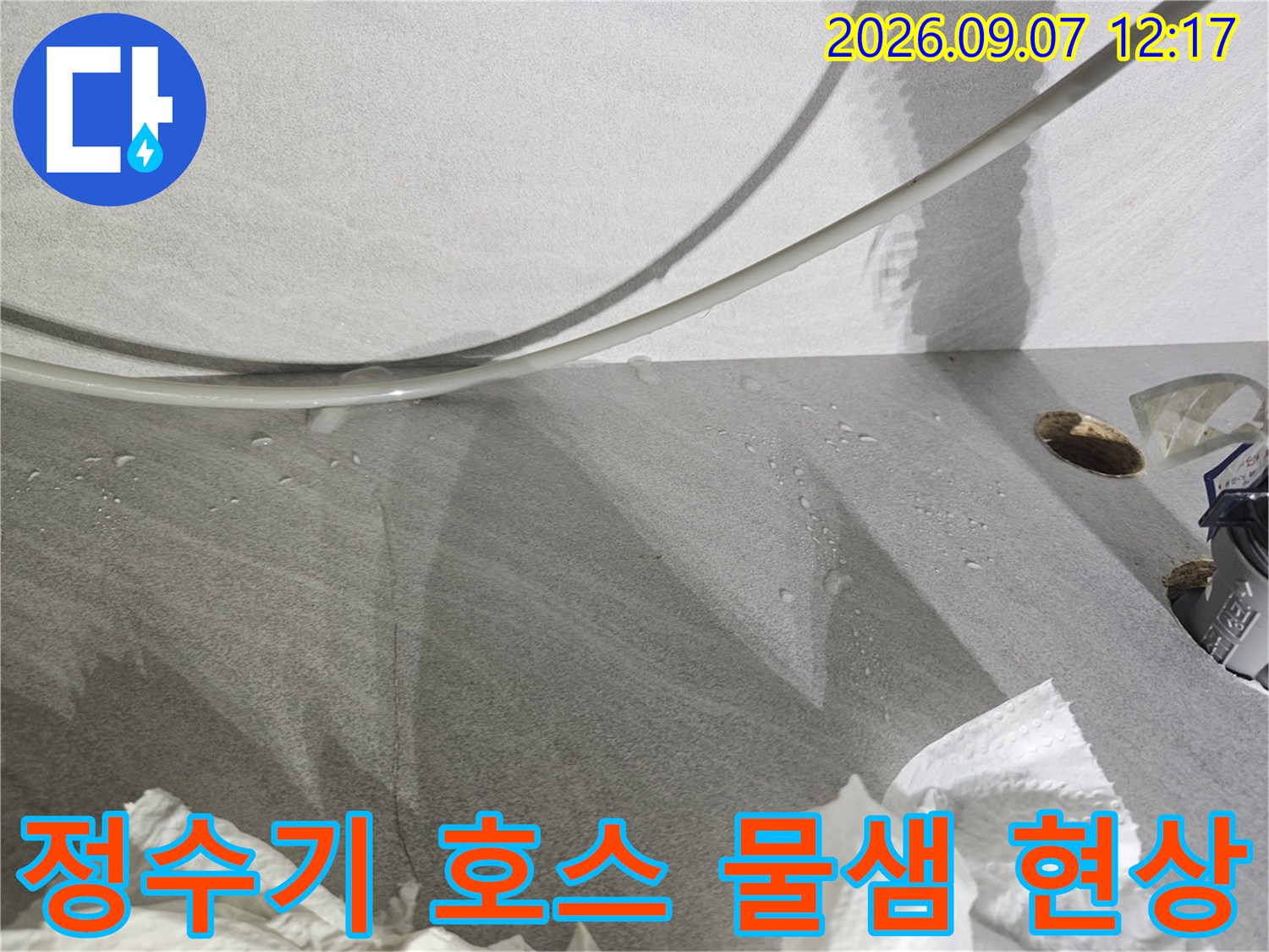 주방 싱크대 하단 정수기 연결 호스에서 물이 새어 나오는 모습입니다.