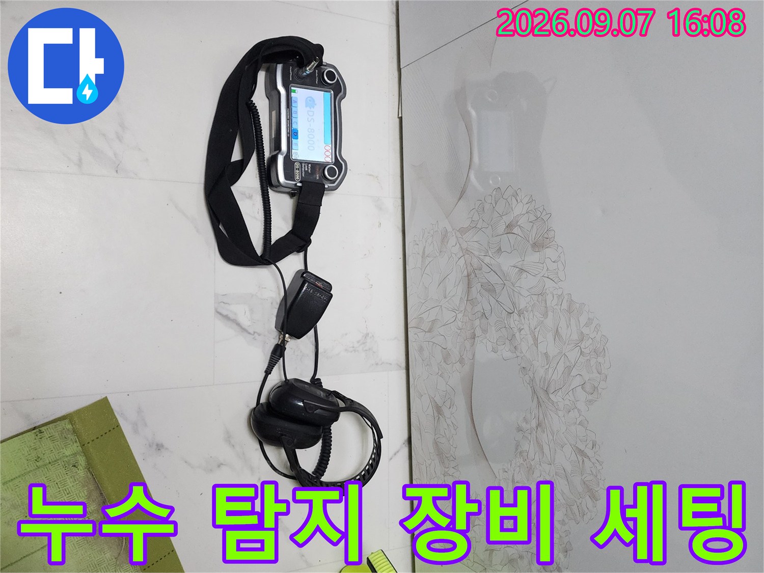 싱크대 앞 바닥에 놓인 전문적인 누수 탐지용 기구들입니다.