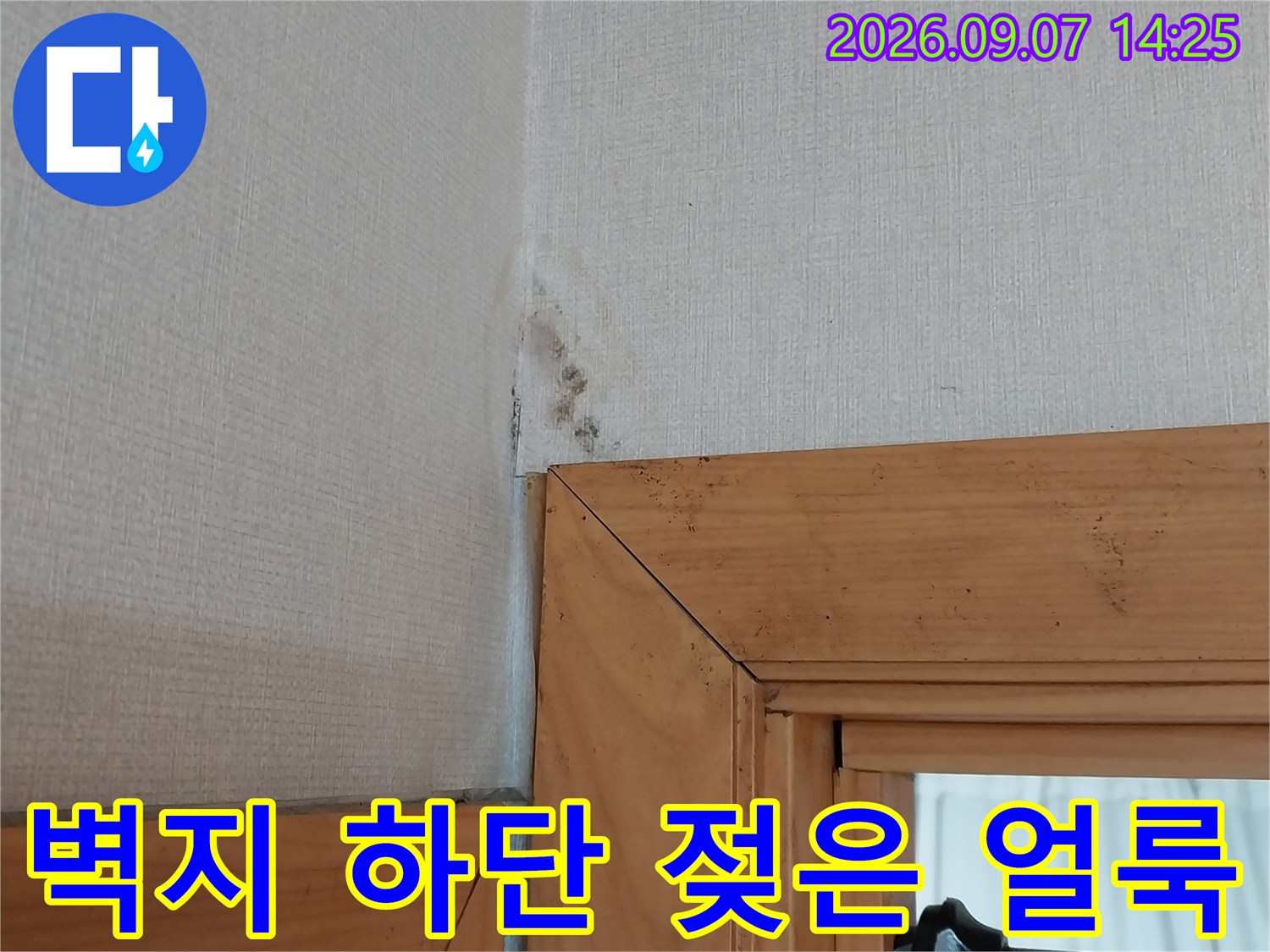 창틀 아래 벽면의 습기로 인한 변색된 벽지