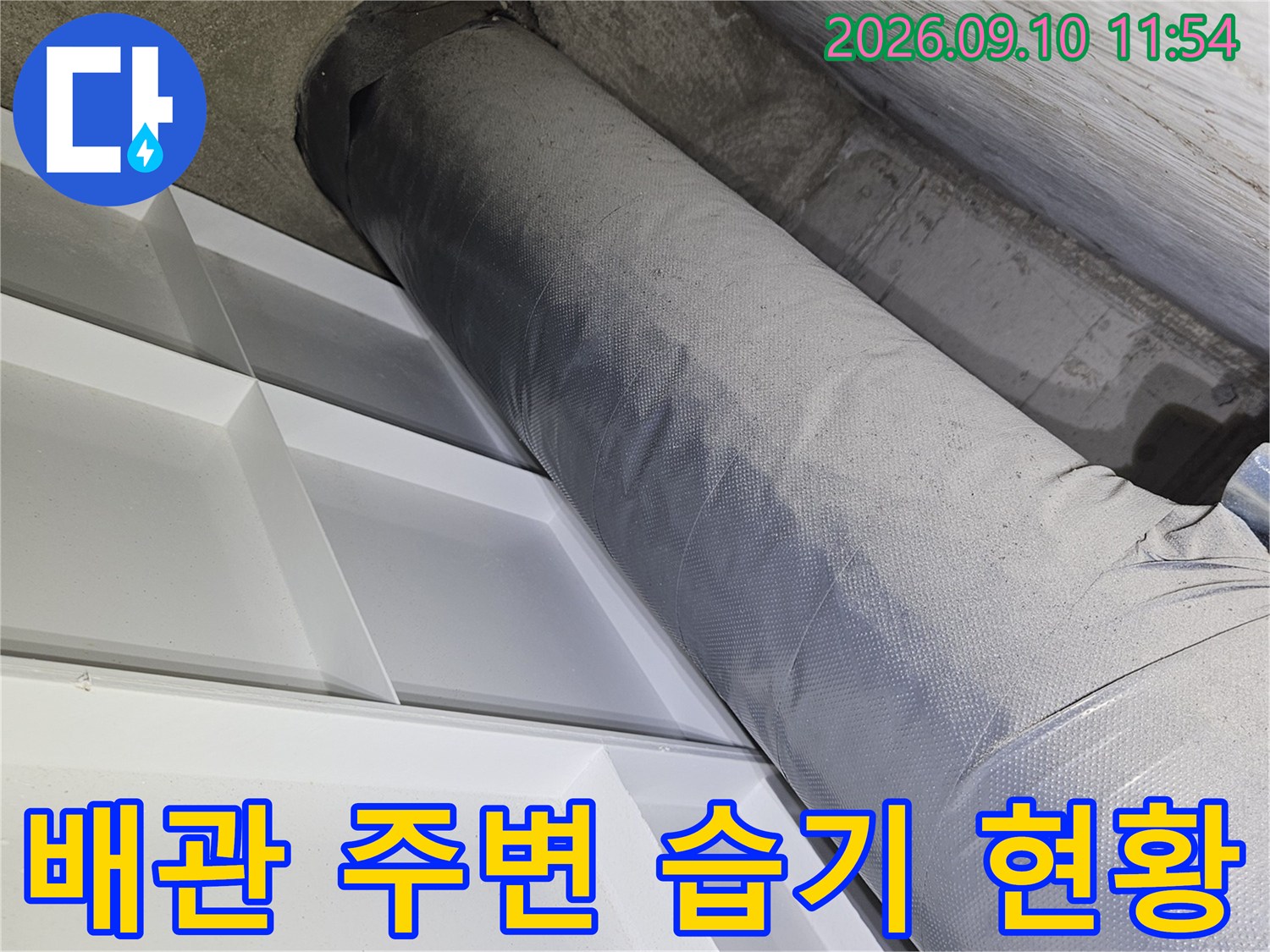 천장 내부 배관과 습기가 스며든 벽면의 근접 촬영본입니다.