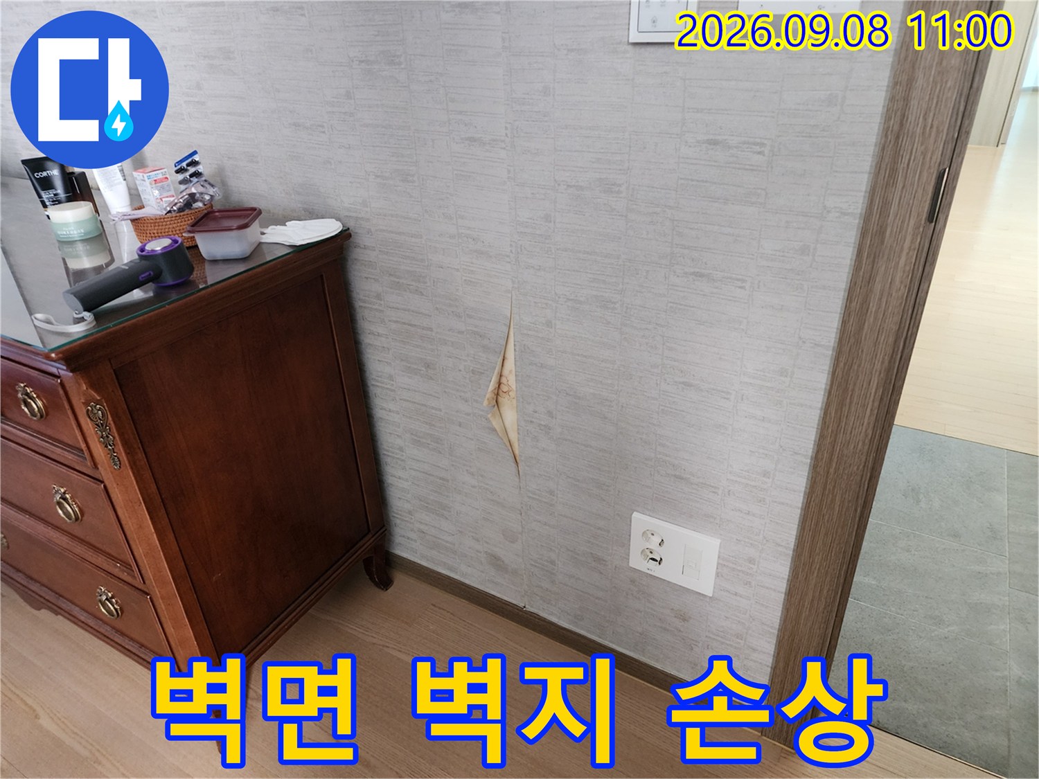 가구 뒤쪽 벽면에 발생한 벽지 파손 부위를 촬영하였습니다.