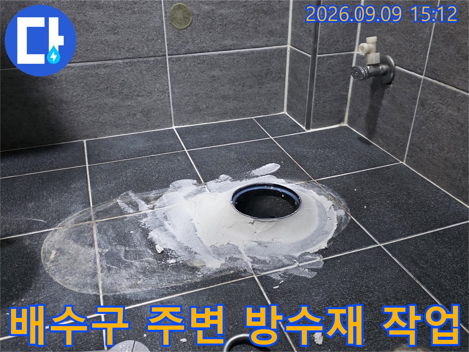 타일 바닥의 배수구 주변에 하얀색 방수 자재를 넓게 펴 바른 상태입니다.