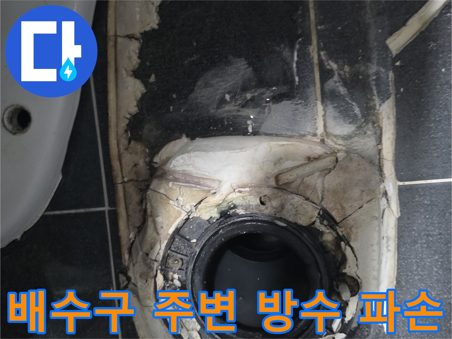 화장실 배수구 주변의 파손된 방수층과 노출된 배관 상태
