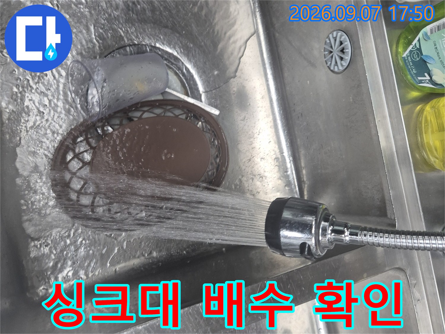 물줄기를 싱크대 배수구로 흘려보내며 누수 여부를 살피는 모습입니다.