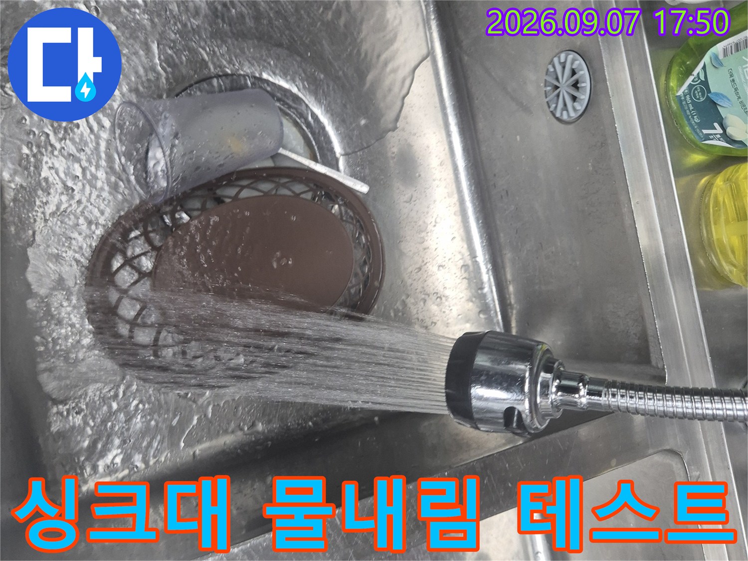 싱크대 배수구로 시원하게 물을 내려보며 누수 여부를 최종 점검하는 모습입니다.