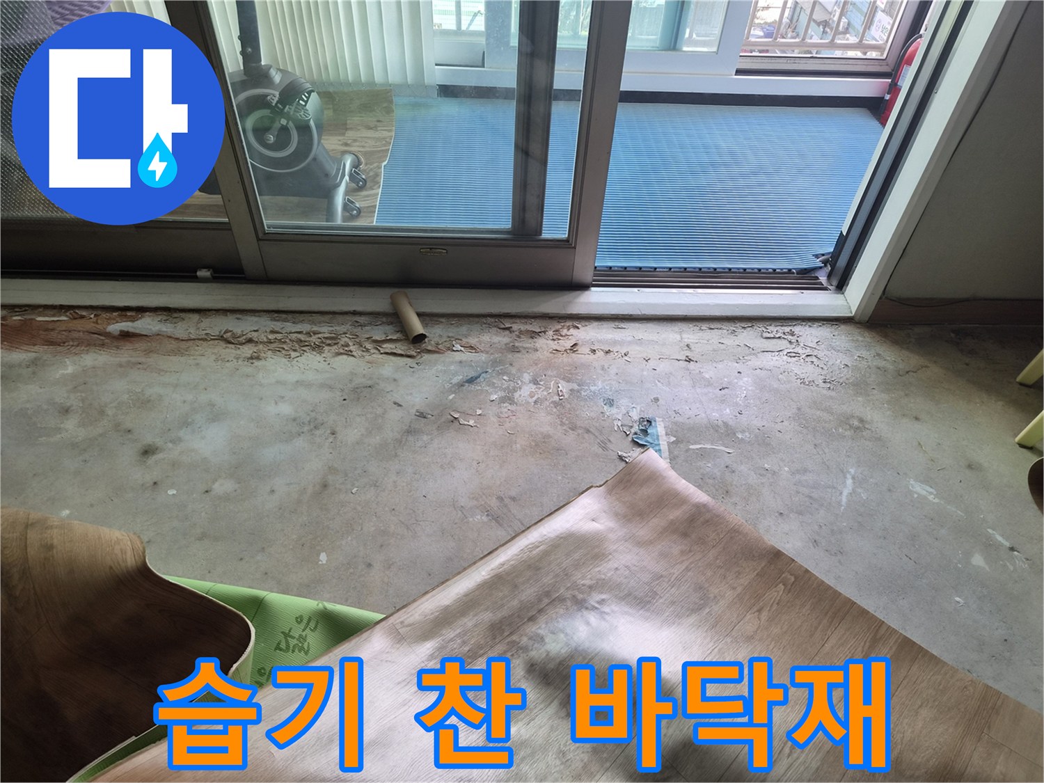 누수로 인해 젖고 들뜬 상태의 거실 바닥 마감재 사진