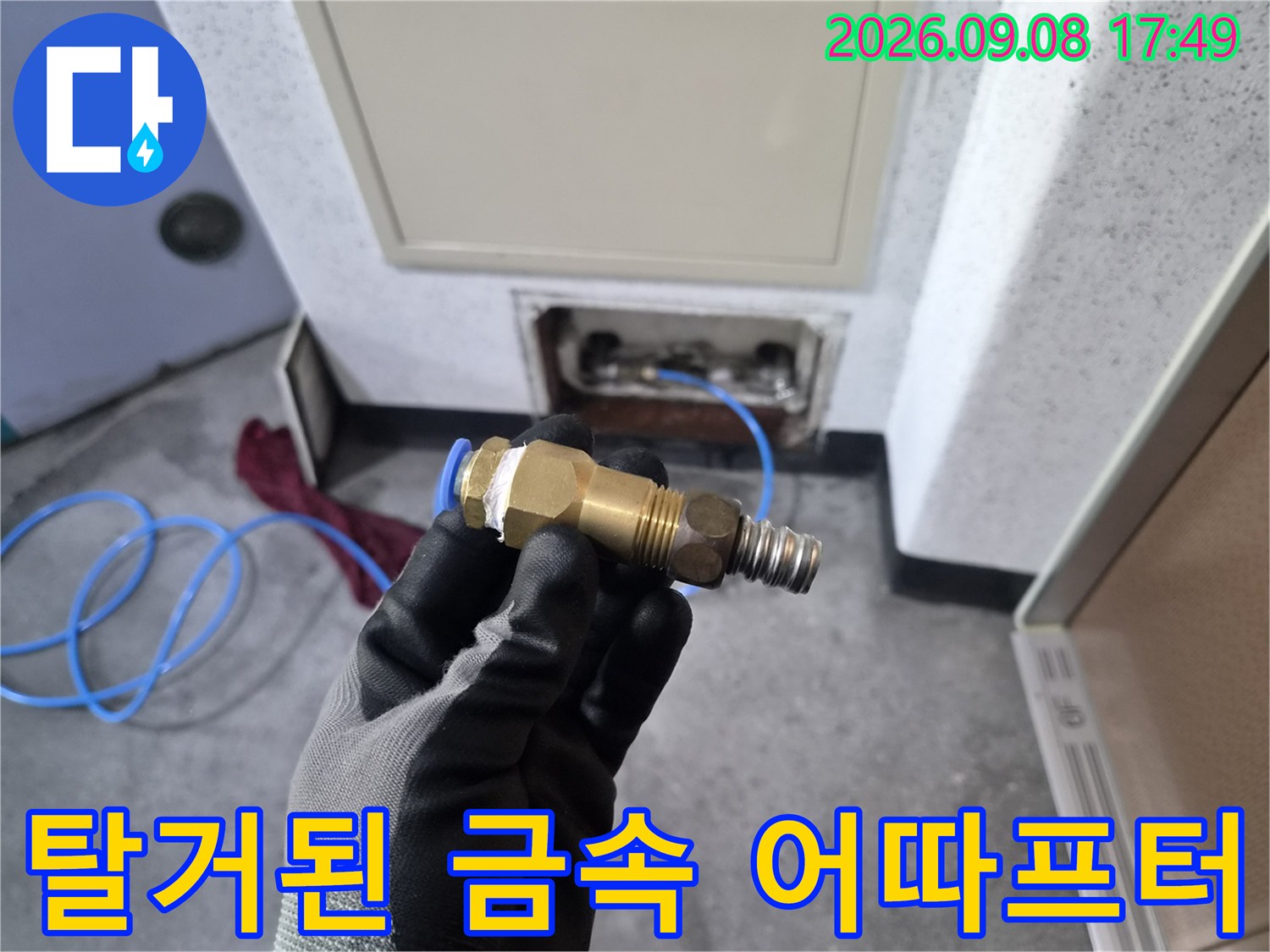 누수의 원인이 된 금속 연결 부품을 들고 있는 모습입니다.