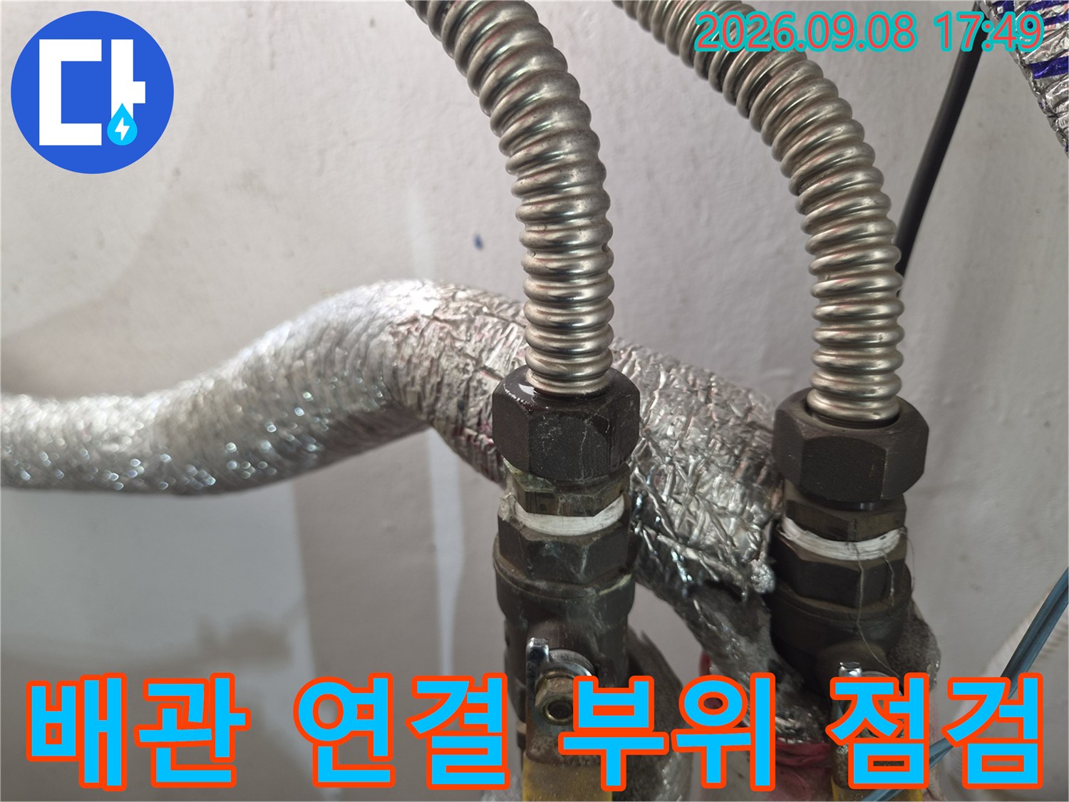 보일러 배관의 금속 연결 어댑터와 밸브 근처 모습입니다.