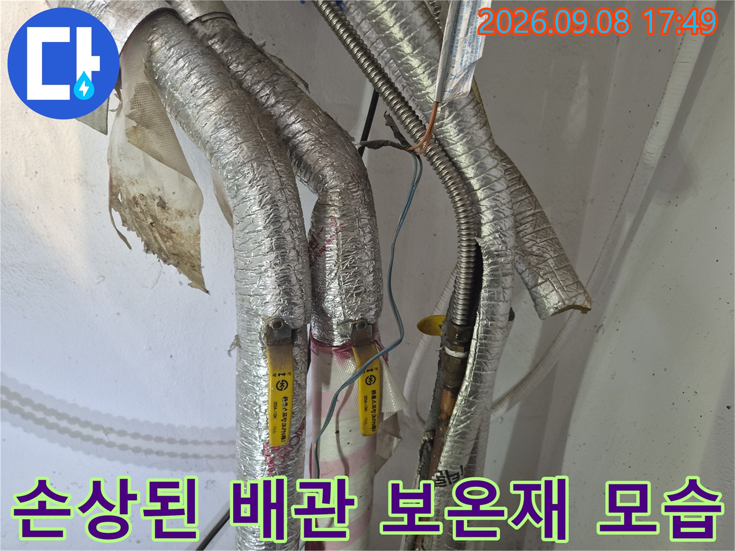 찢어진 은박 보온재와 노출된 배관 연결 부품의 상세 모습