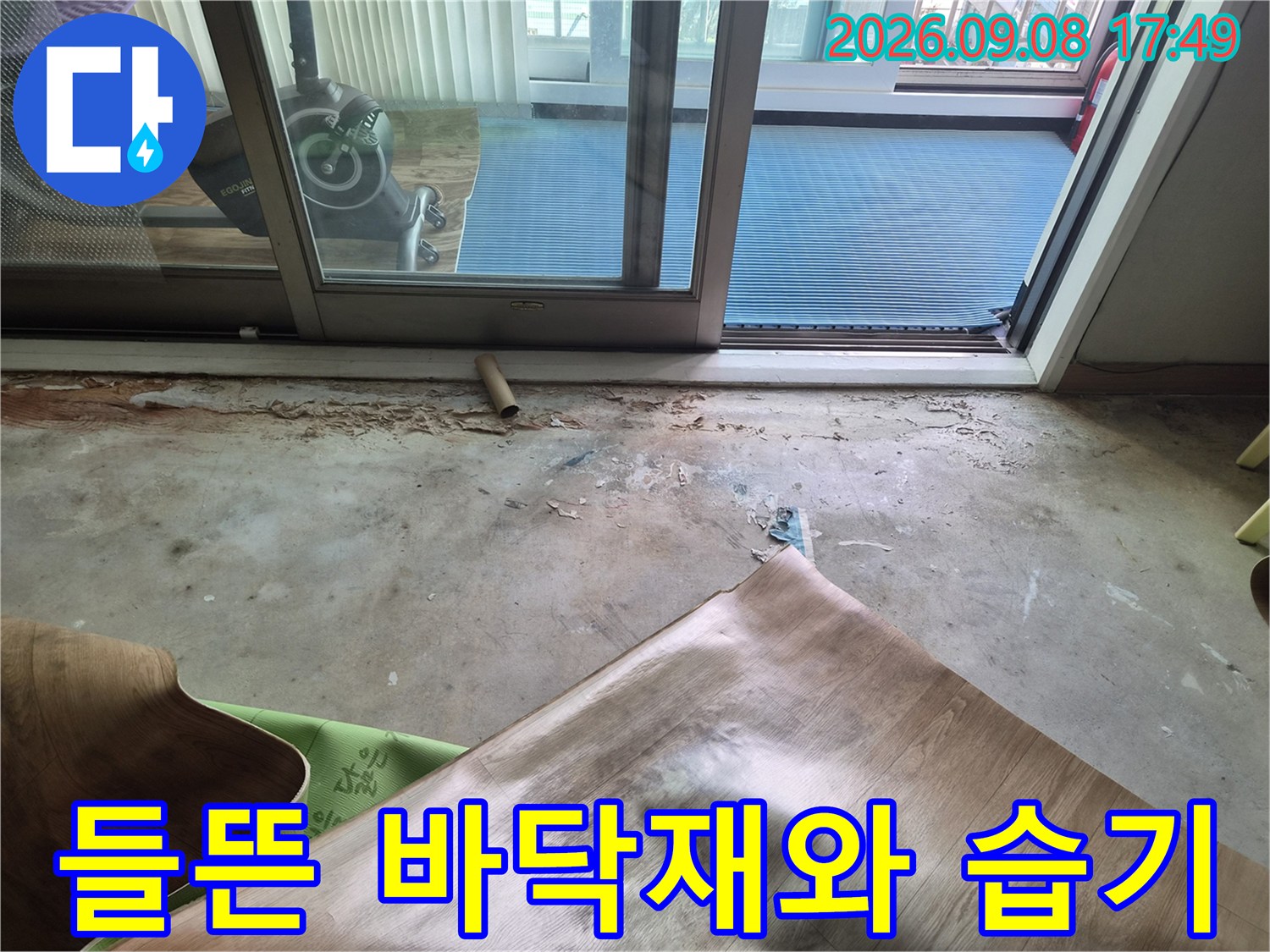 창문 근처 베란다 바닥의 마감재가 벗겨지고 습기가 머문 현장 모습입니다.