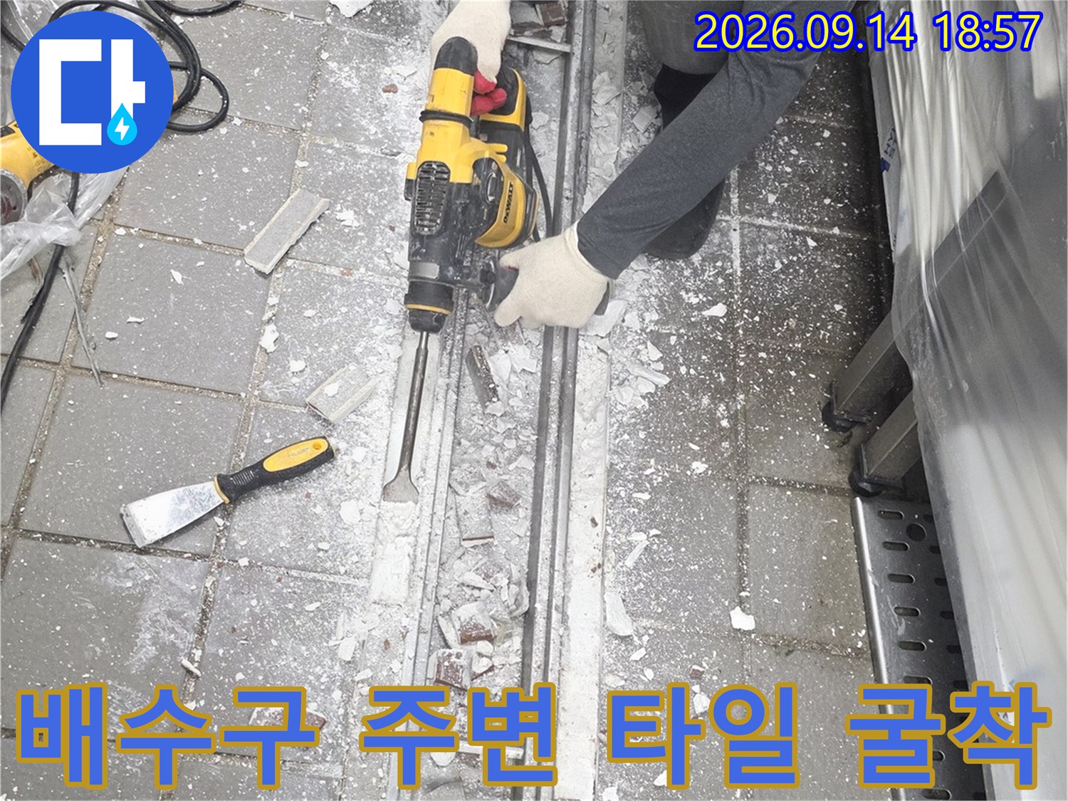 전동 드릴로 트렌치 옆 바닥 콘크리트를 파내는 공사 현장