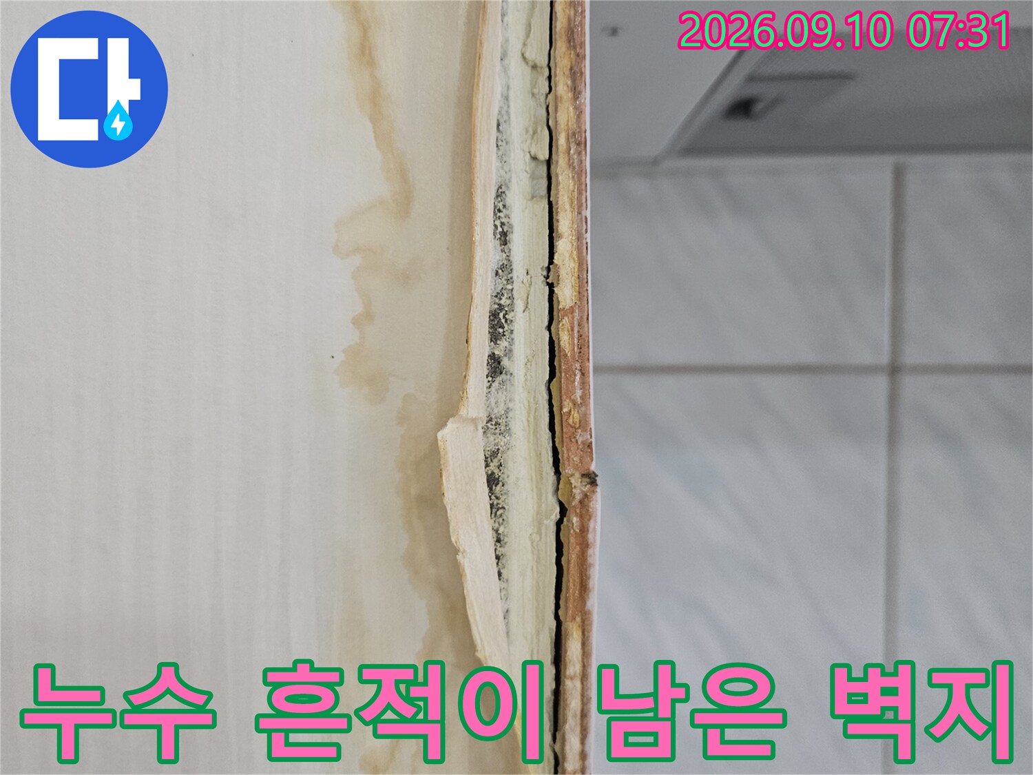 누수 피해로 인해 변색되고 들뜬 벽지 하단 부위
