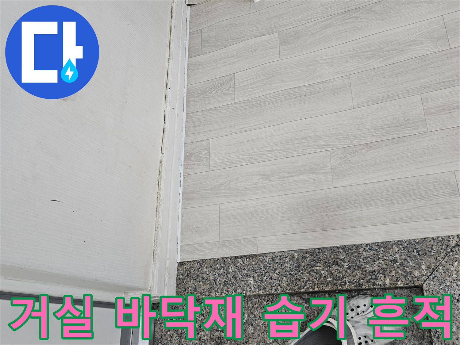 물샘으로 인해 변색된 거실 바닥재와 대리석 경계부