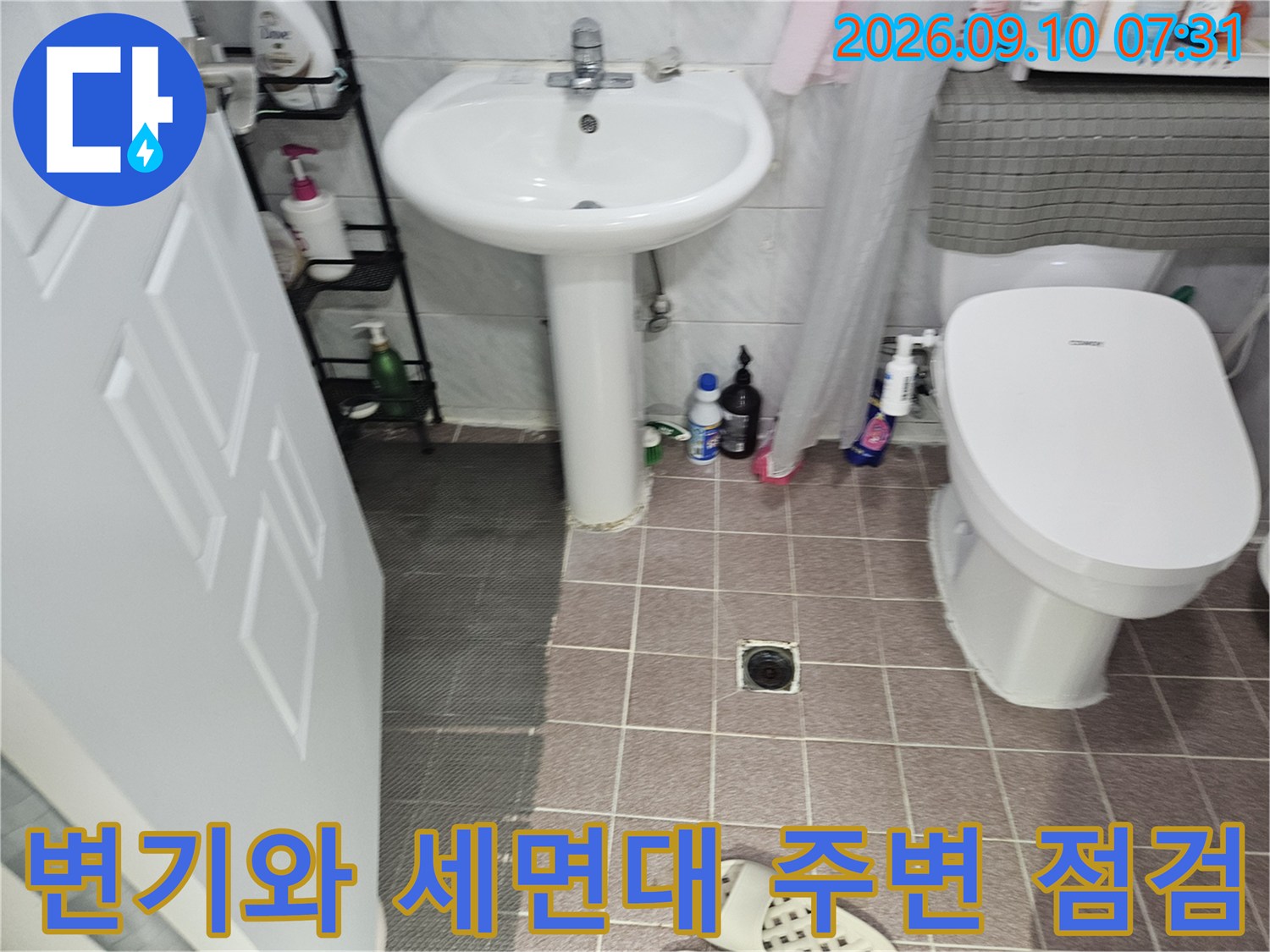 욕실 변기 및 세면대 설치 부근의 타일 상태를 나타내는 이미지입니다.