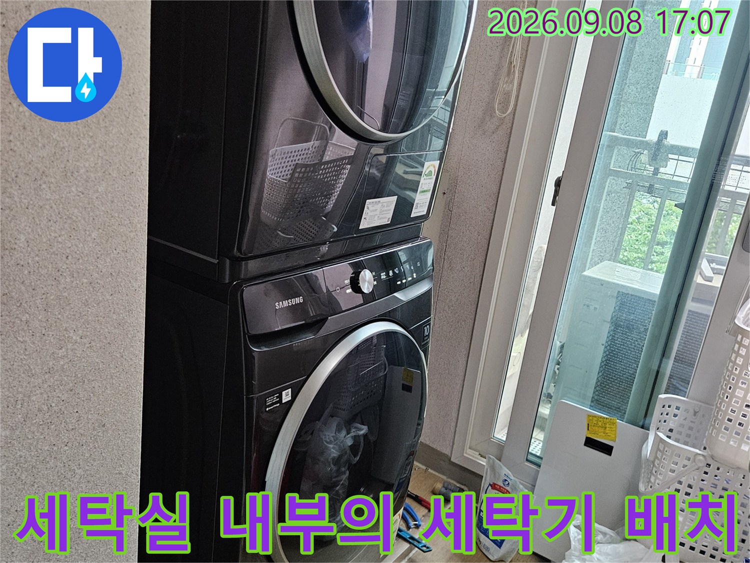 두 대의 드럼 세탁기가 설치된 깨끗한 세탁실 현장 사진입니다.