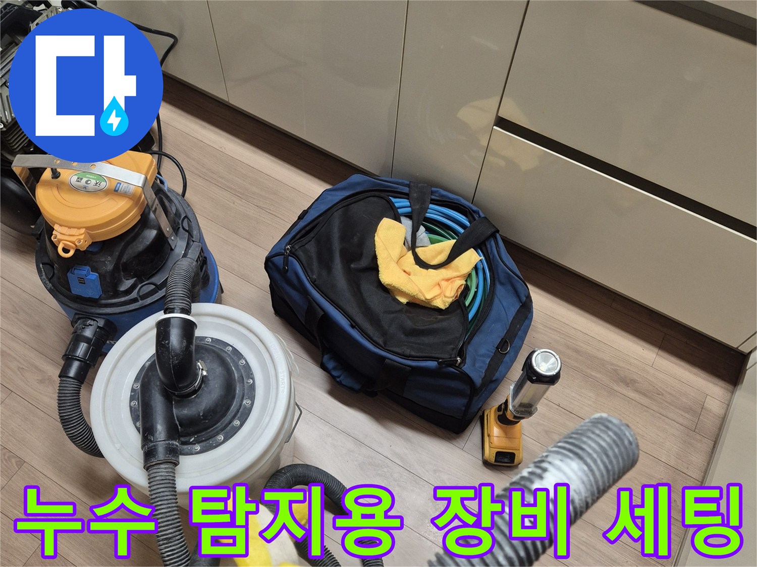 싱크대 하부 작업 공간에 놓인 공압 테스트기 및 청소용 진공 흡입 도구
