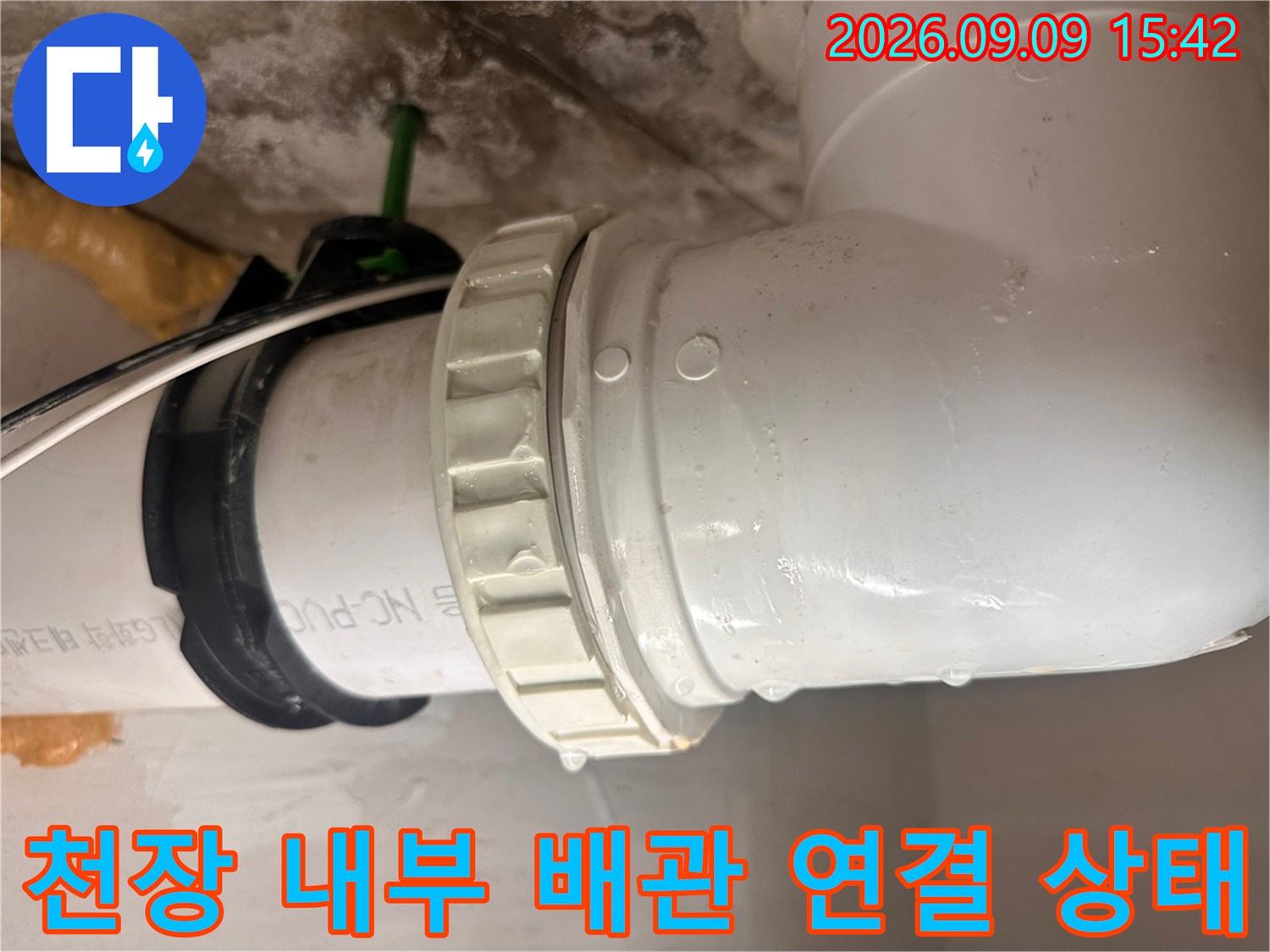 화장실 천장 슬라브 아래 설치된 하수 배관의 연결 부위를 확인하는 장면입니다.