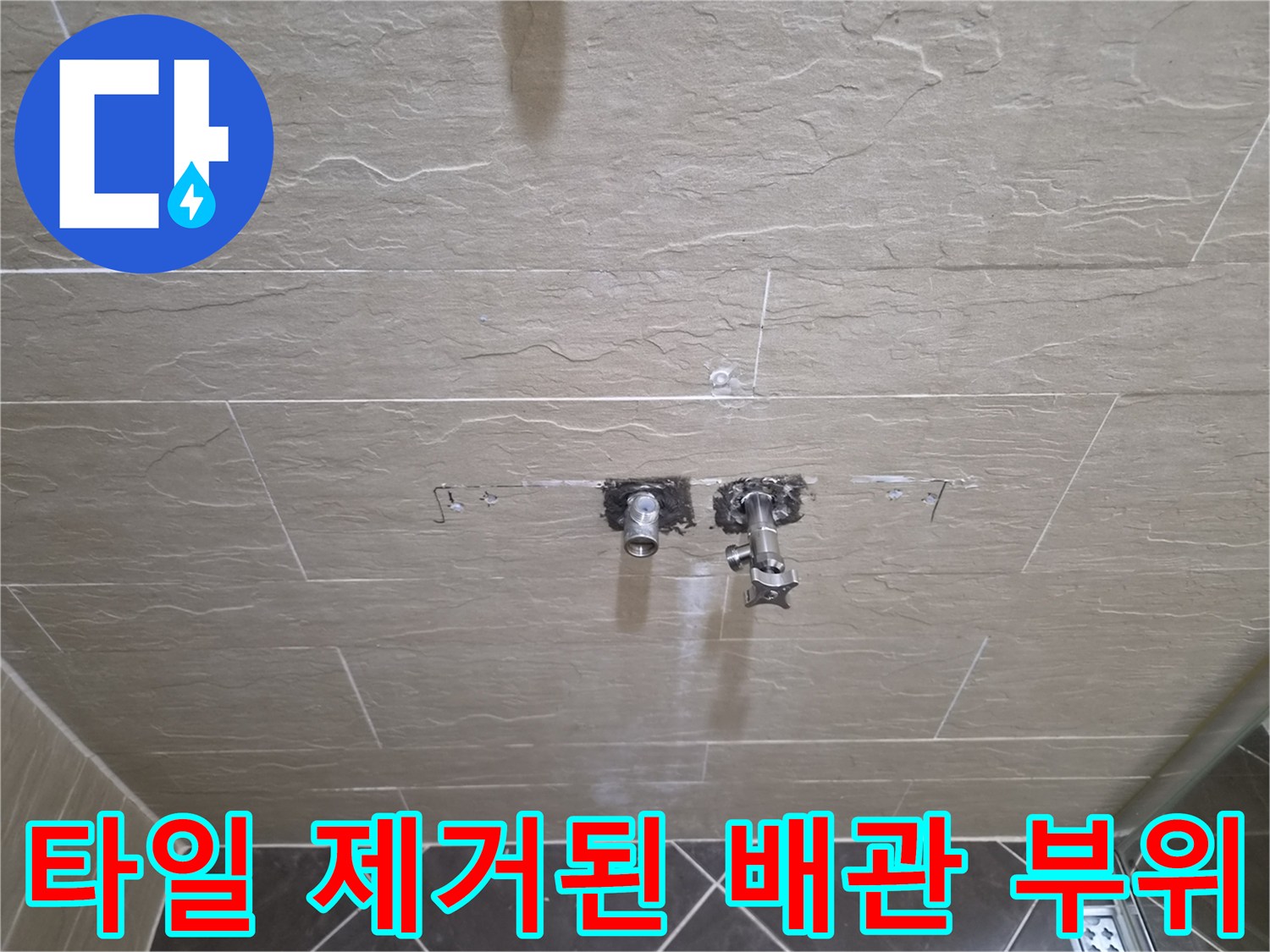 샤워 수전 연결부를 확인하기 위해 타일을 걷어낸 현장 모습입니다.
