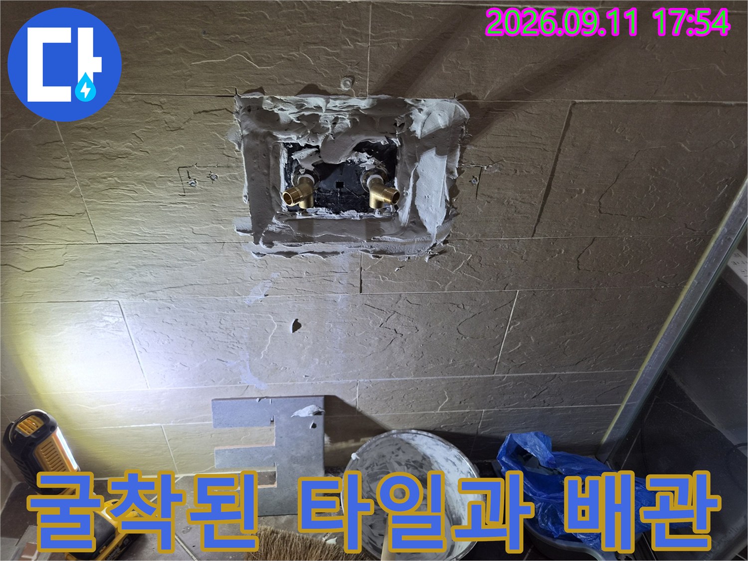 욕실 벽면 굴착-노출된 금색 수전 부속의 모습입니다.