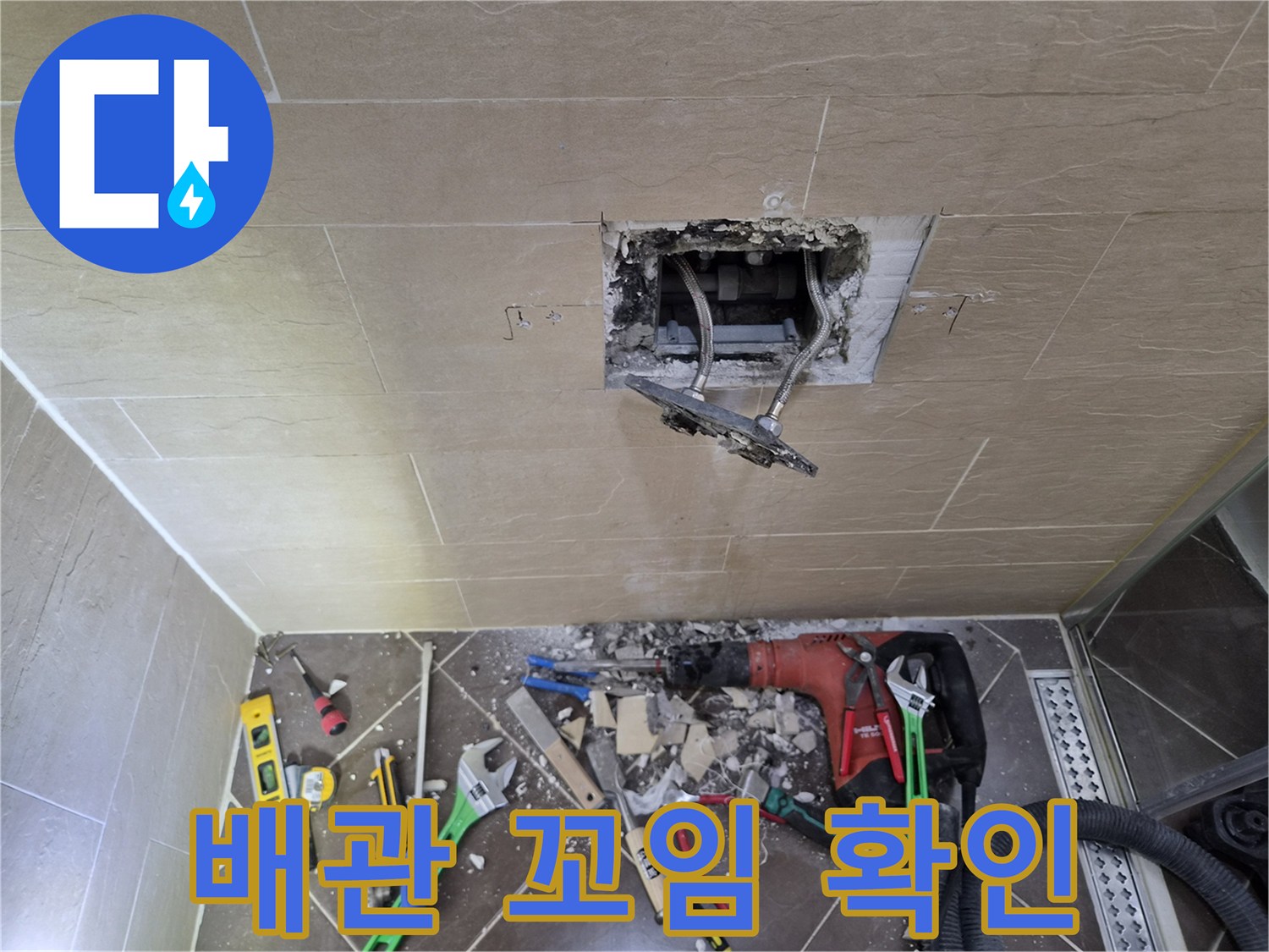 타일 제거 후 드러난 내부 배관과 주변 작업 도구들