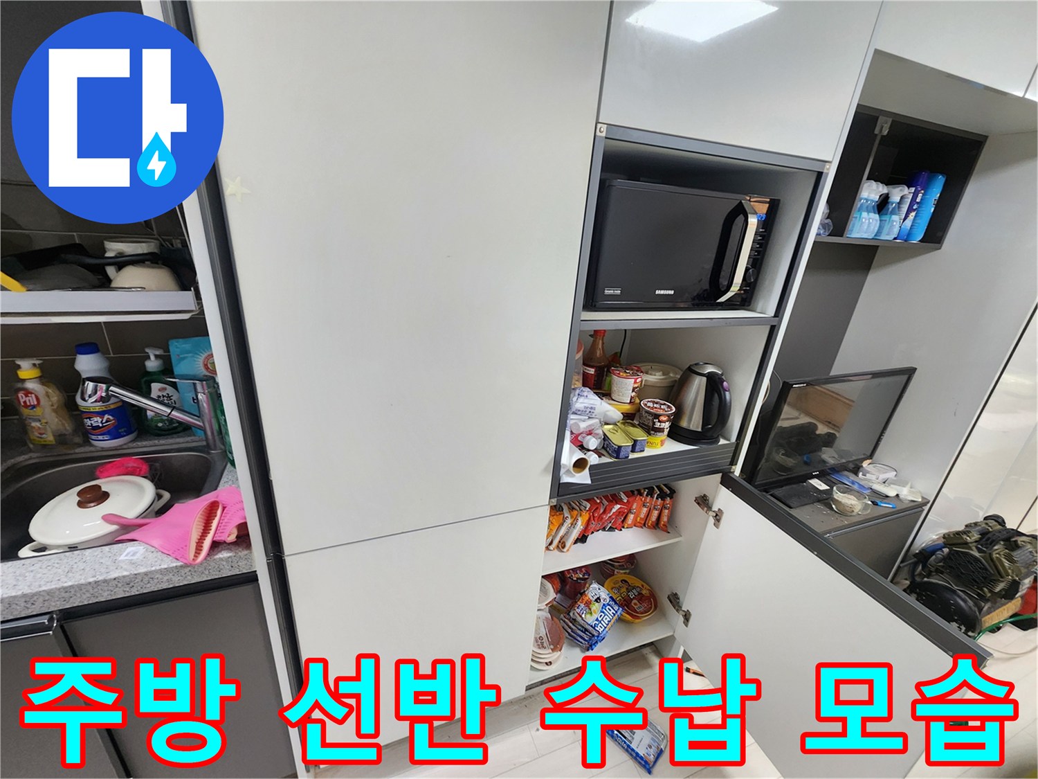 전자레인지와 주방 용품들이 정리되어 있는 싱크대 하부장 내부입니다.