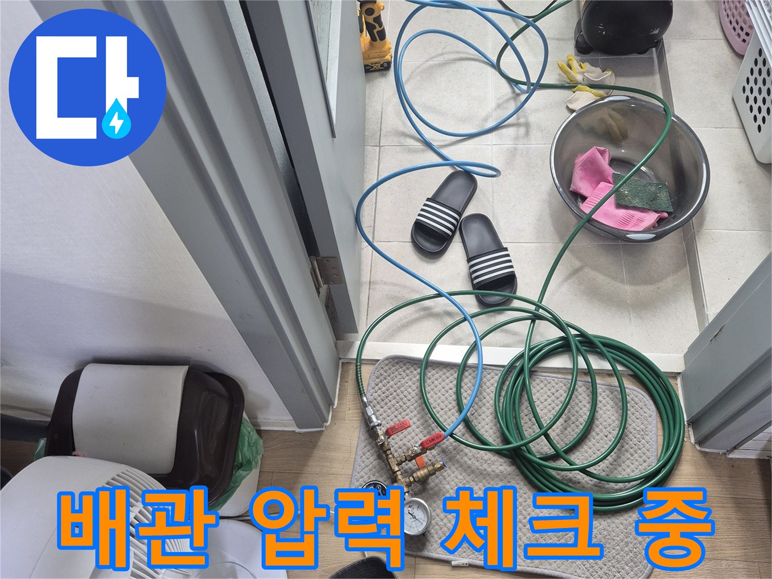 바닥에 펼쳐진 누수 점검용 호스와 게이지 장치