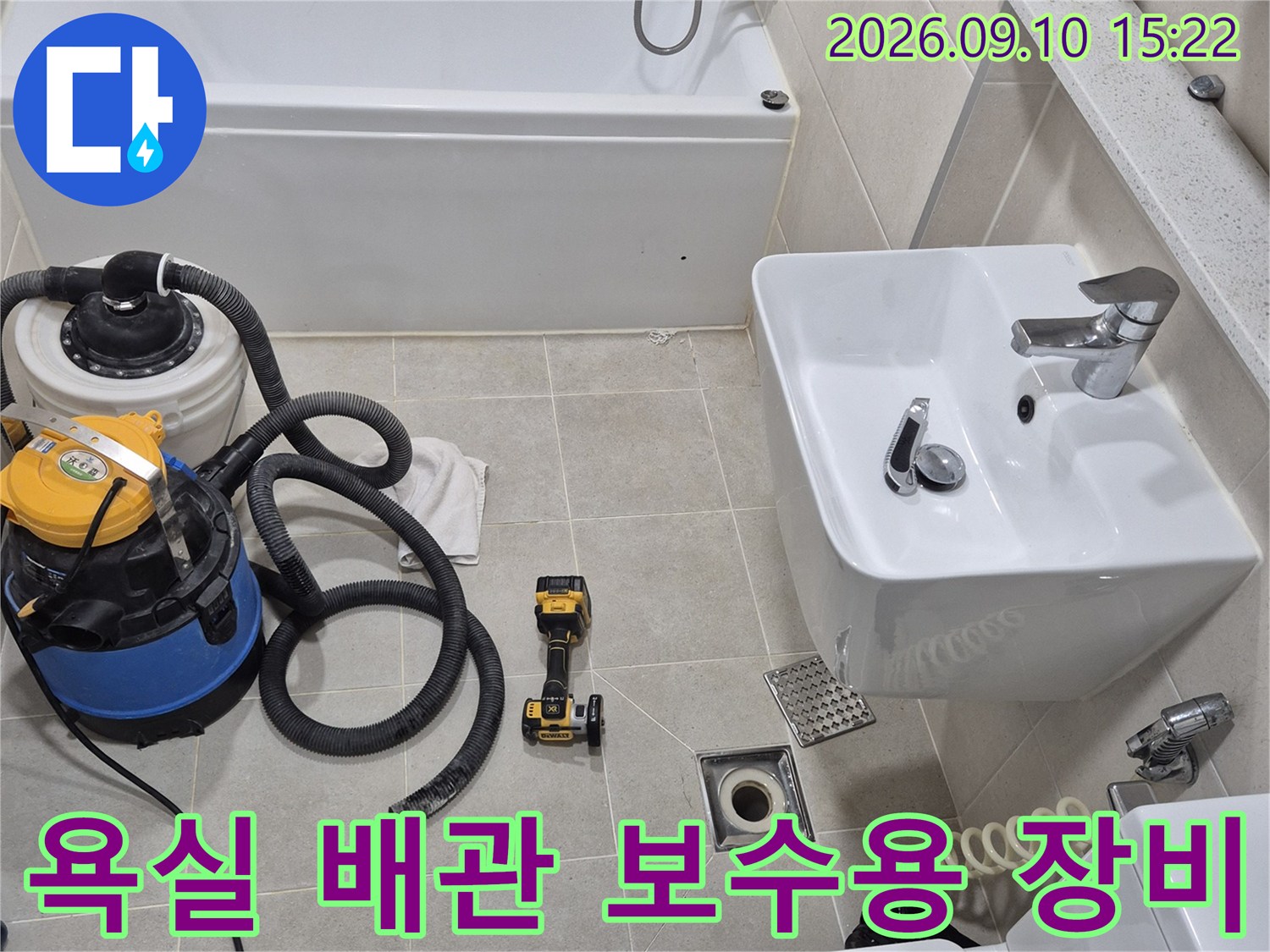 세면대와 변기 사이 바닥에 배치된 누수 수리용 전문 장비들