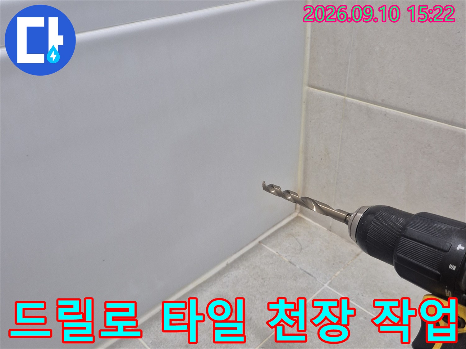 전동 드릴을 사용하여-화장실 천장 타일 부위를 타공하는 모습