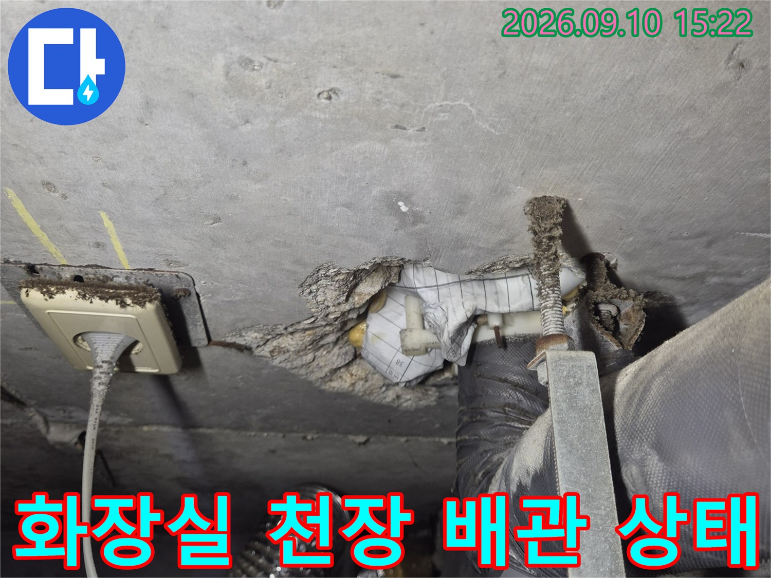 화장실 점검구 안쪽의 굵은 배관과 연결 부위를 촬영한 사진입니다.
