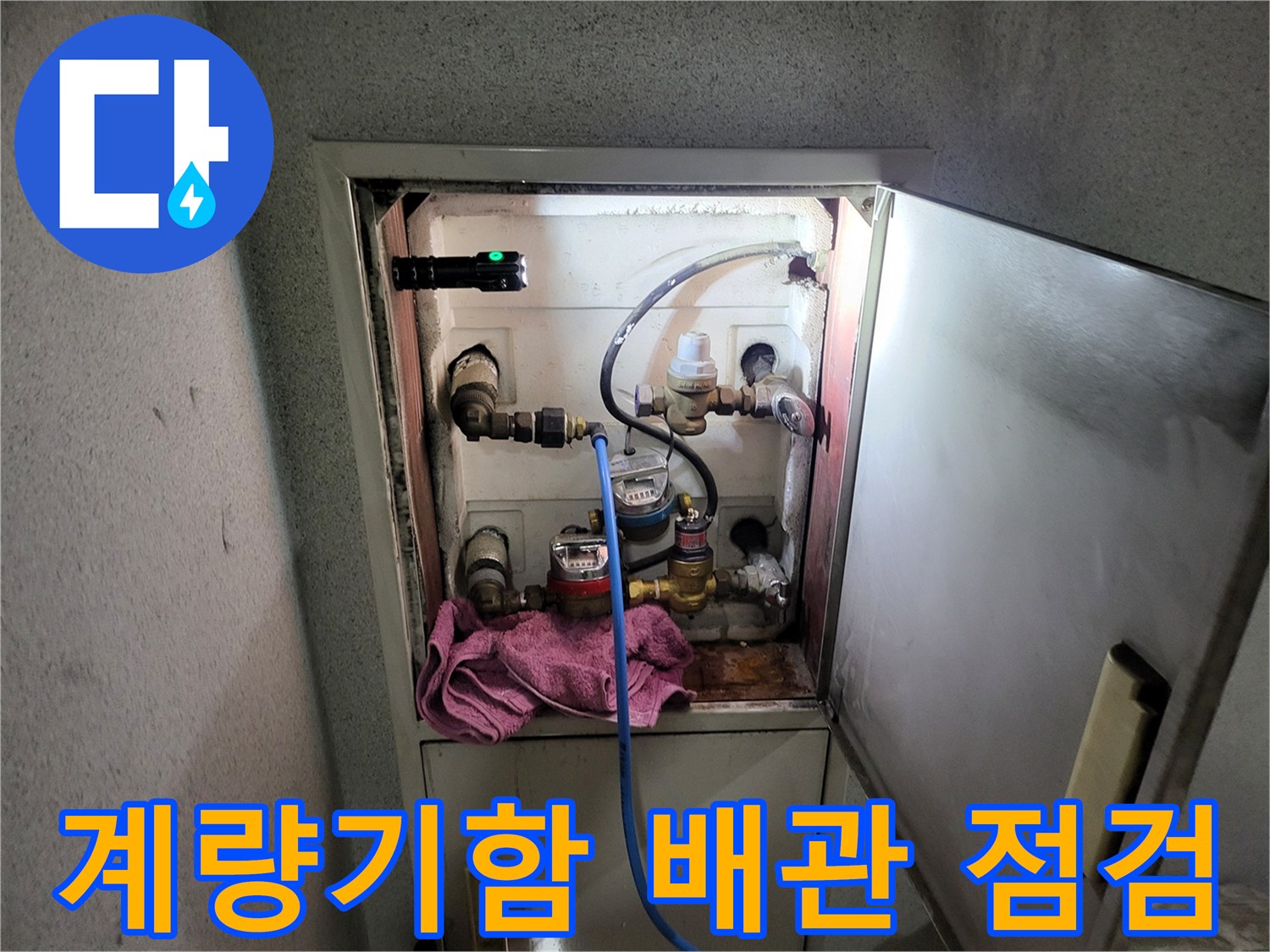 수도 계량기함 내부의 배관과 압력계를 확인하는 모습입니다.