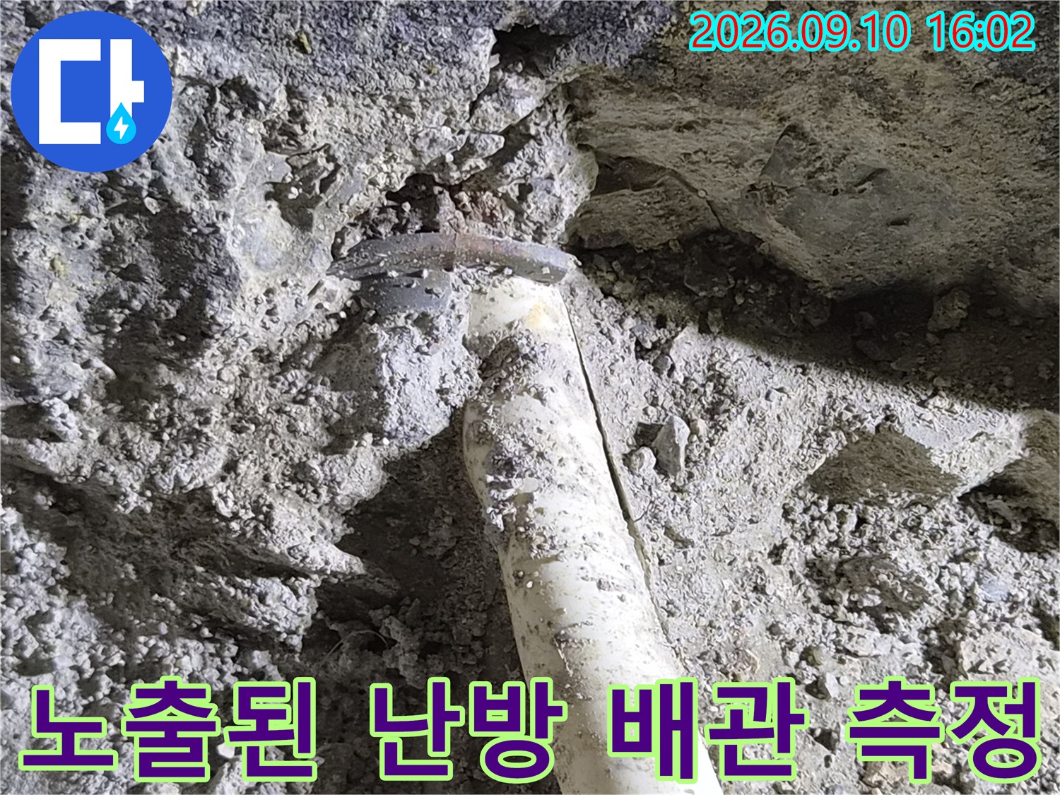 바닥 흙 사이로-드러난 배관의-규격을 버니어캘리퍼스로 체크하는 모습