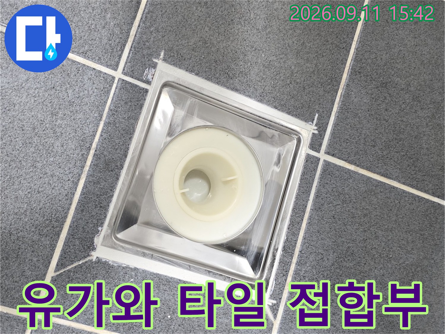 회색 욕실 타일과 배수구 유가의 결합 부위 상세 촬영