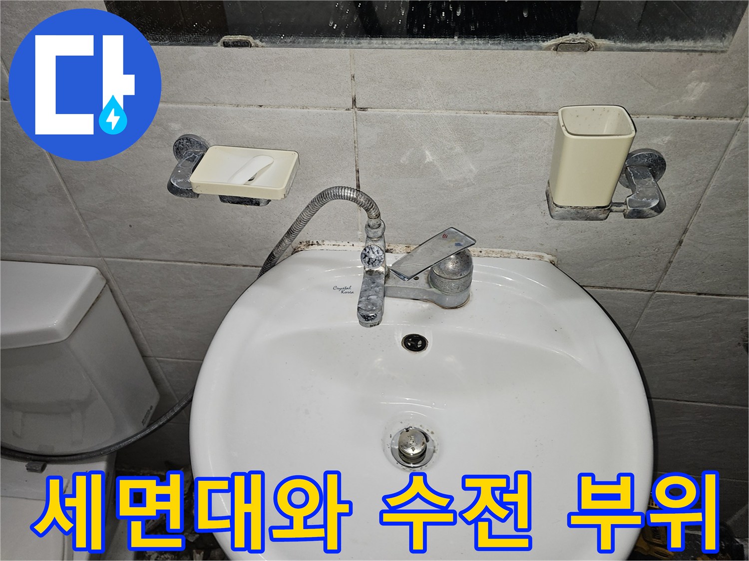 화장실 세면대 수전과 벽면 타일이 촬영된 사진입니다.