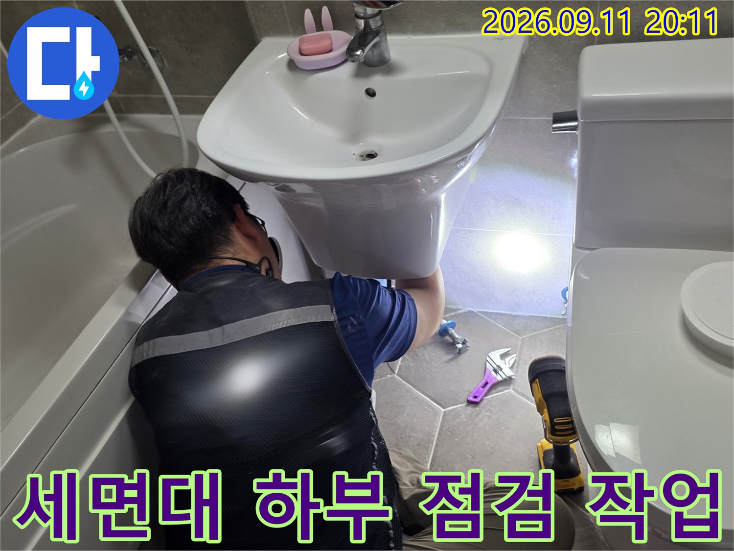 화장실 세면대 밑부분의 누수 지점을 찾아내는 엔지니어의 모습입니다.